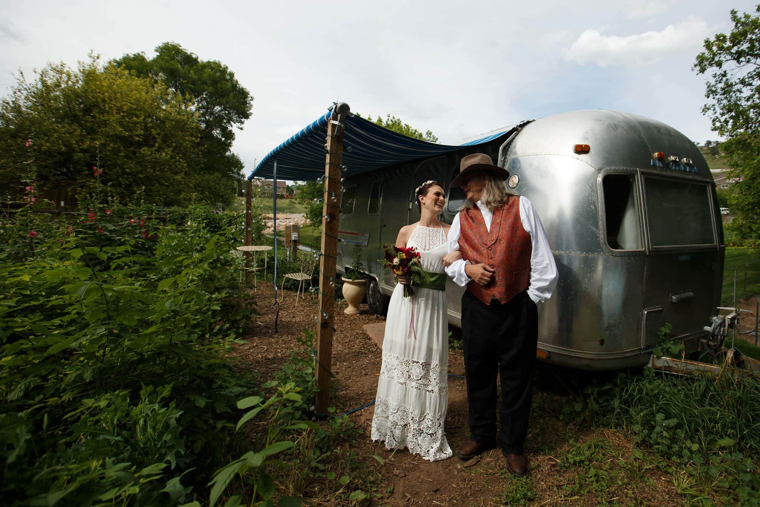Bride and her father stand outside the airstream during her Lyons Farmette wedding