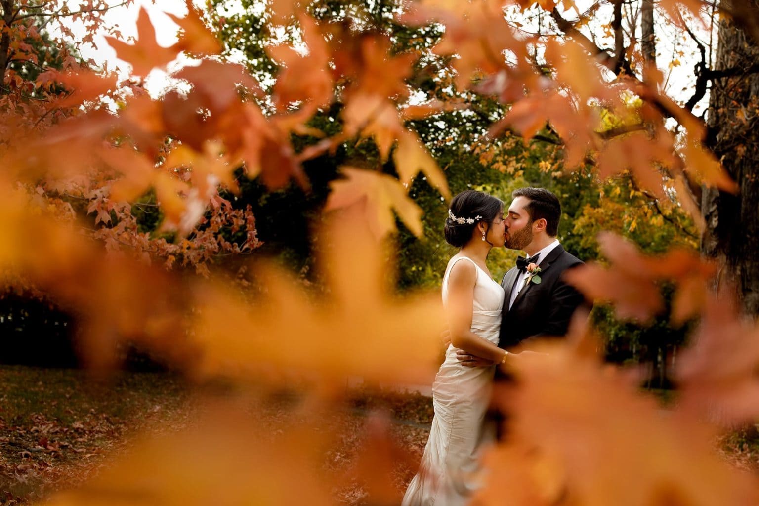 The couple share a kiss surrounded by maple leaves in Boulder, Colorado