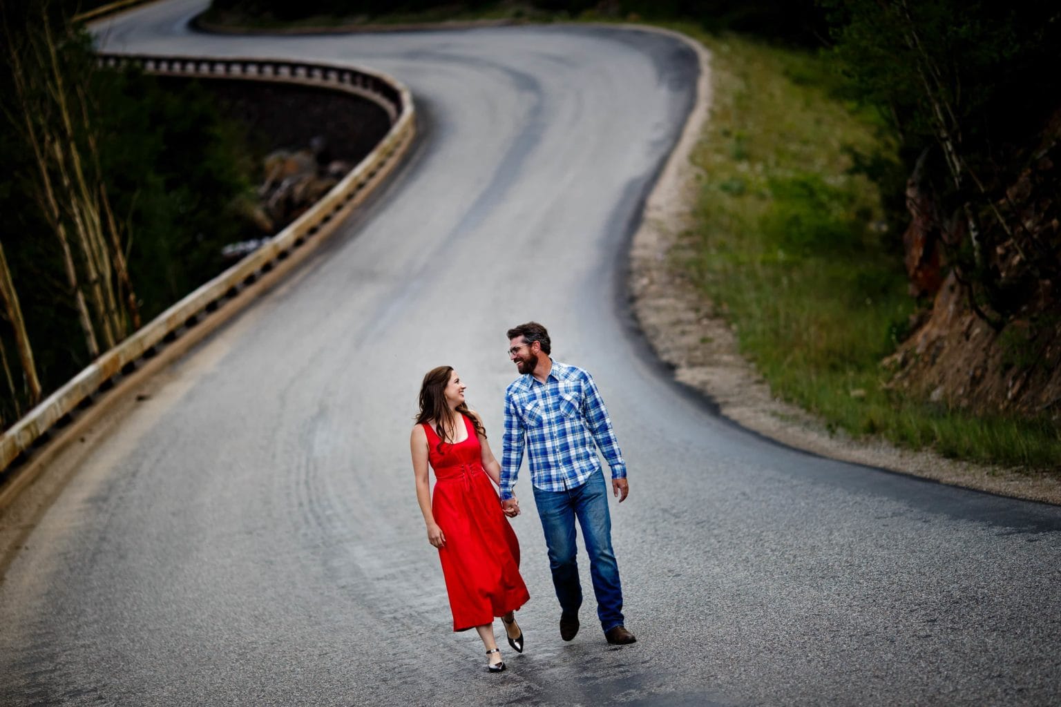 Mallory and Daniel walk hand-in-hand down Guanella Pass Road in Georgetown, Colorado during their engagement session