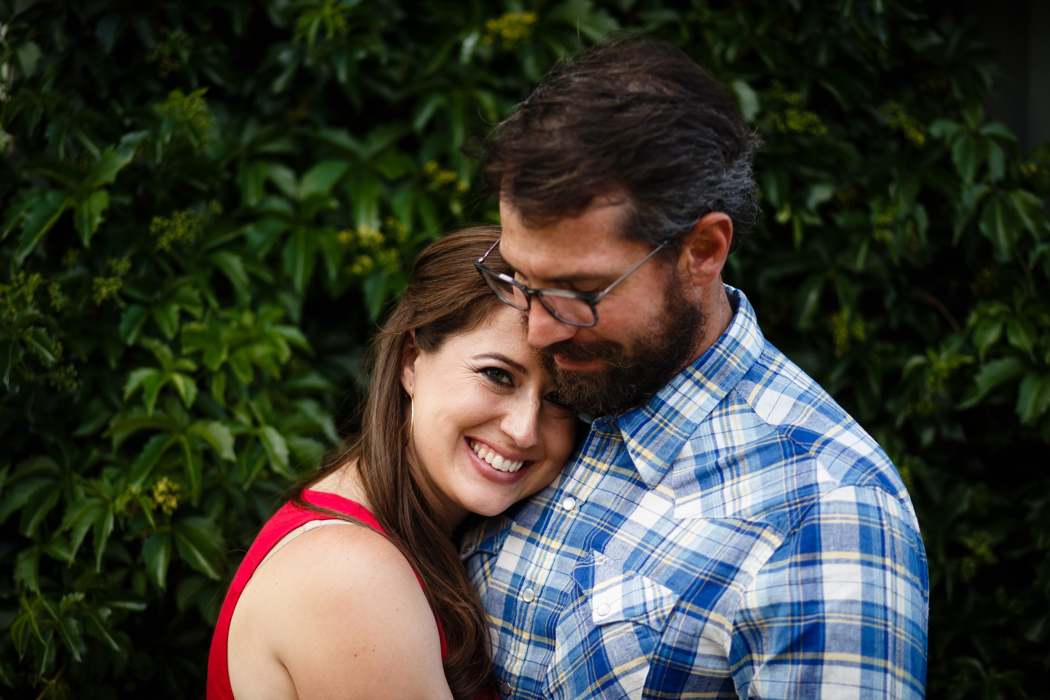 Mallory smiles while hugging daniel in front of a wall of ivy in Georgetown, Colorado