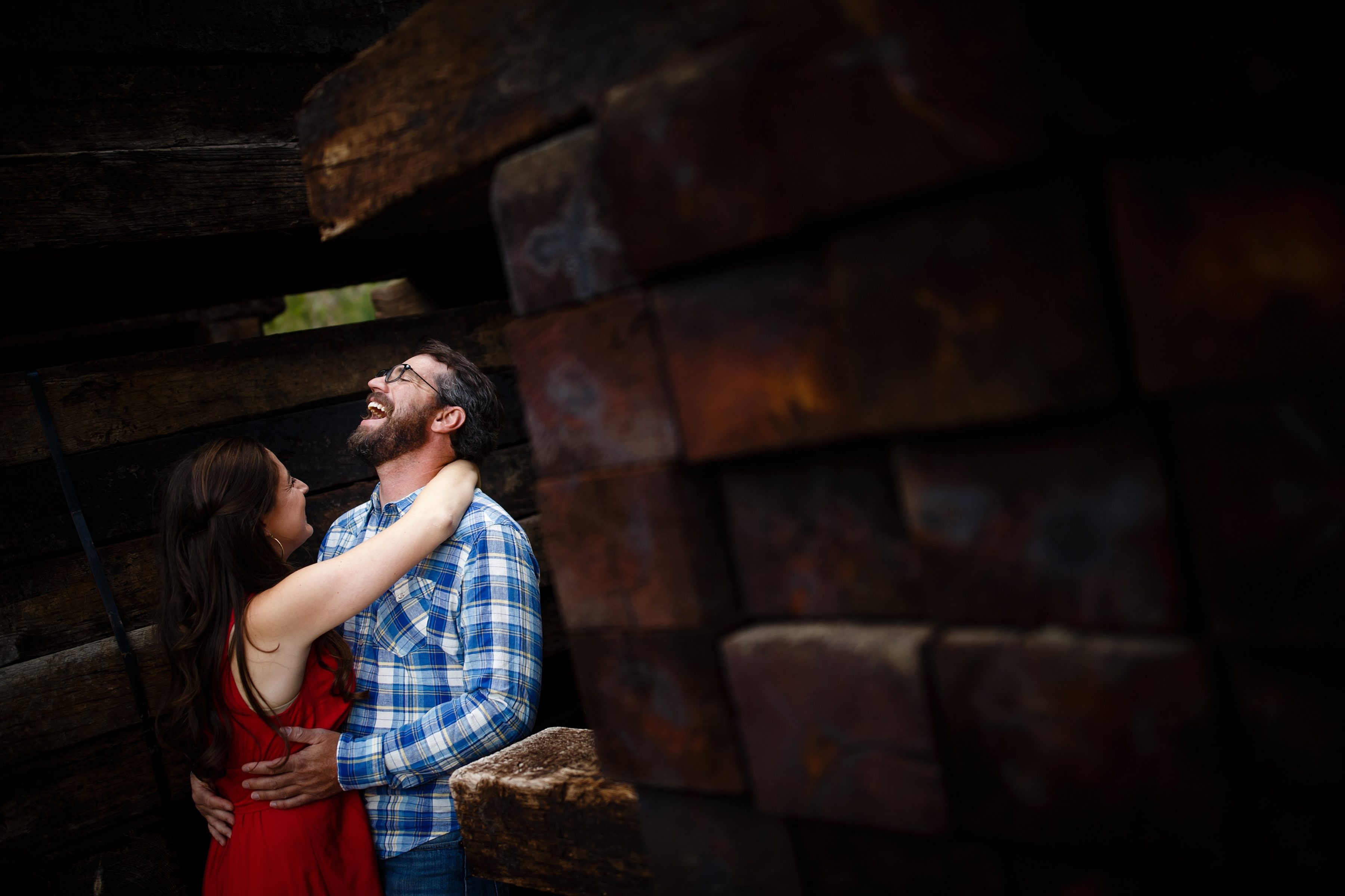 Daniel laughs with his fiancee Mallory next to a stack of railroad ties in Georgetown