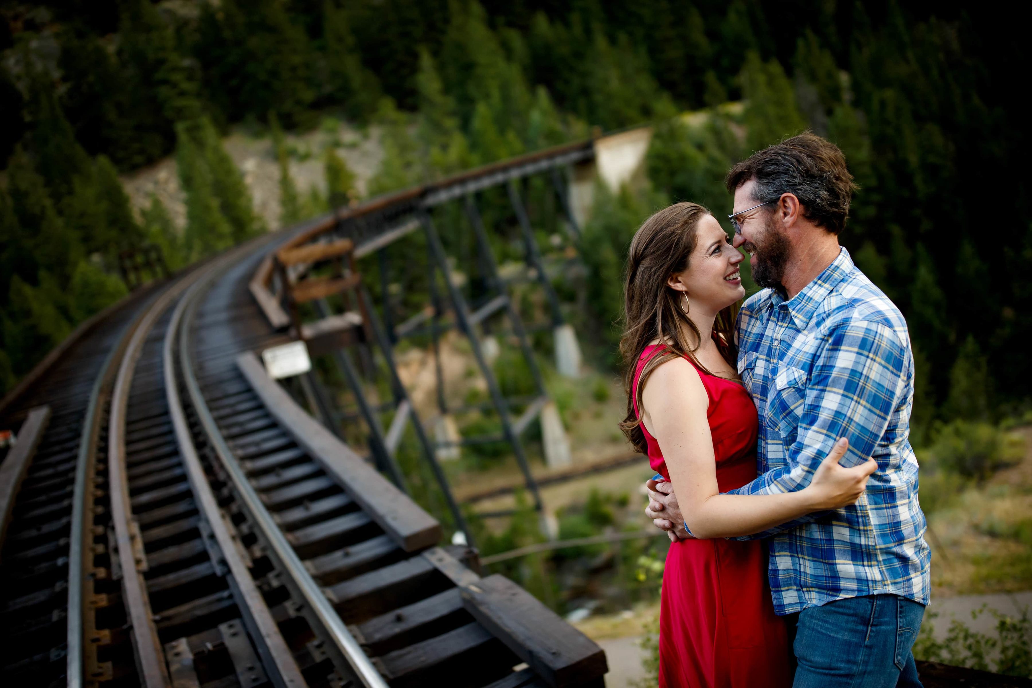 Mallory is embraced by Daniel at the location of his proposal near the train tracks in Georgetown Colorado