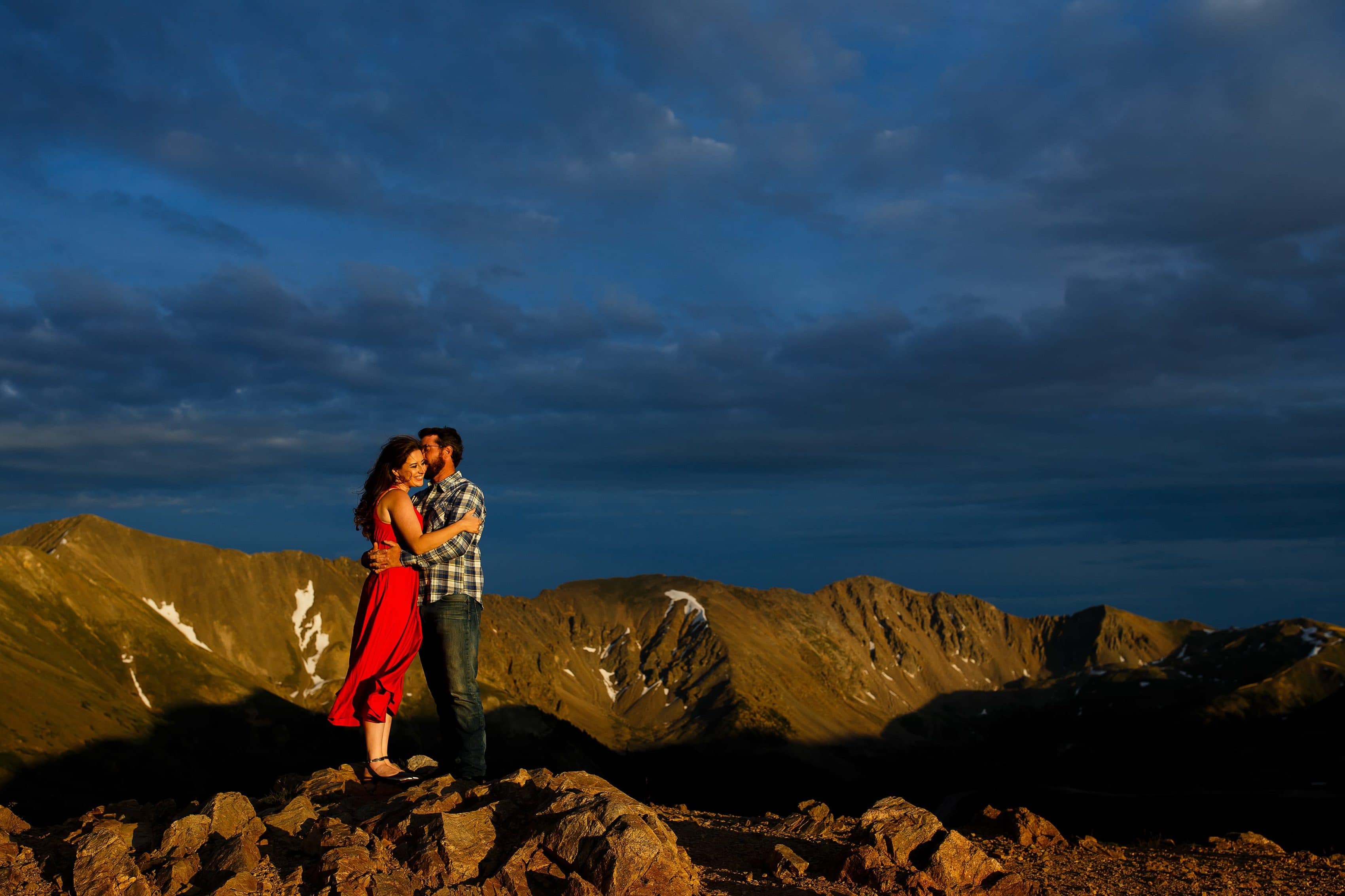 Daniel kisses Mallory as the two embrace on top of Loveland pass as the sun sets near Keystone Colorado