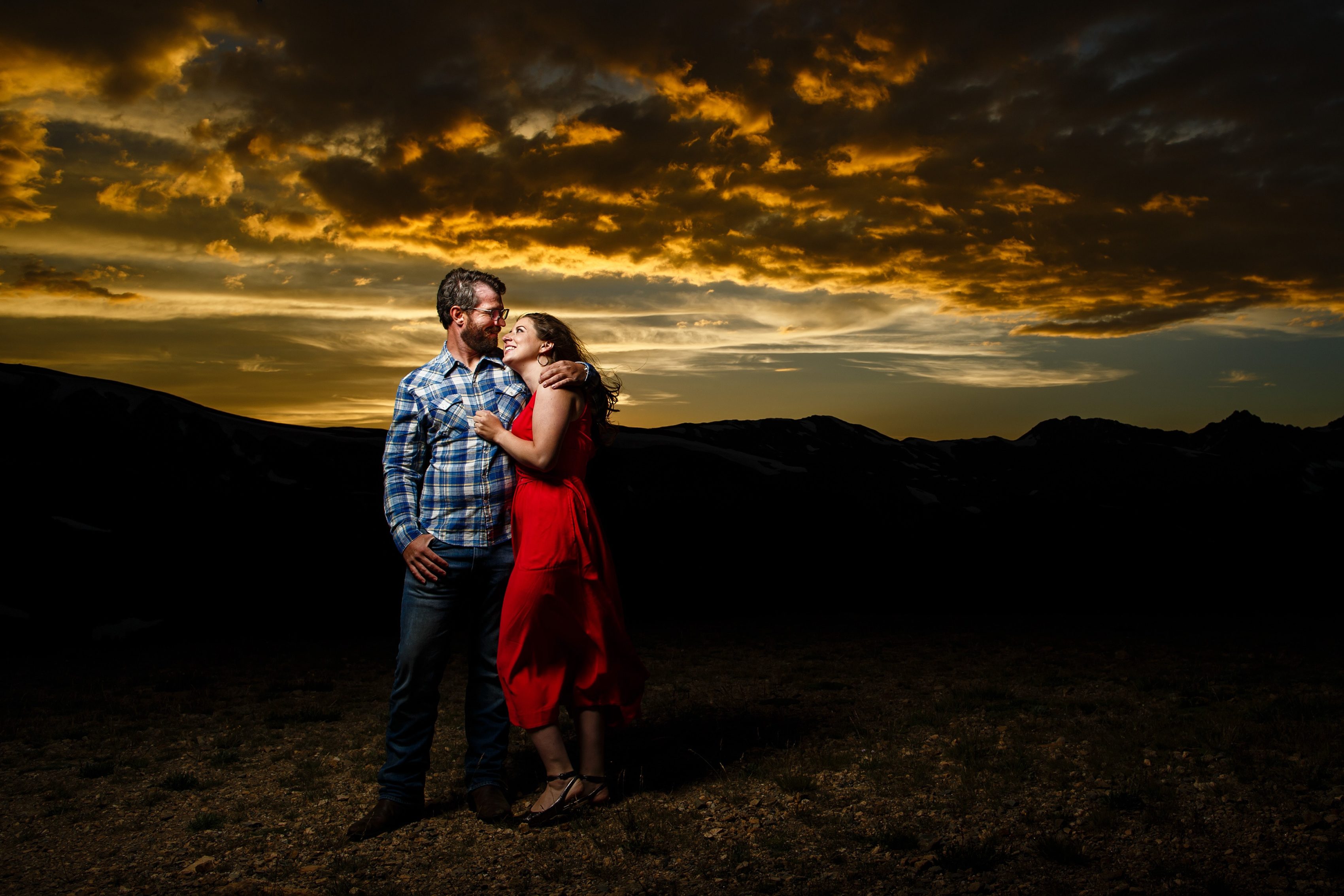 The sun illuminates a beautiful sunset as Mallory and Daniel pose during their summertime engagement photo session atop Loveland Pass near Keystone
