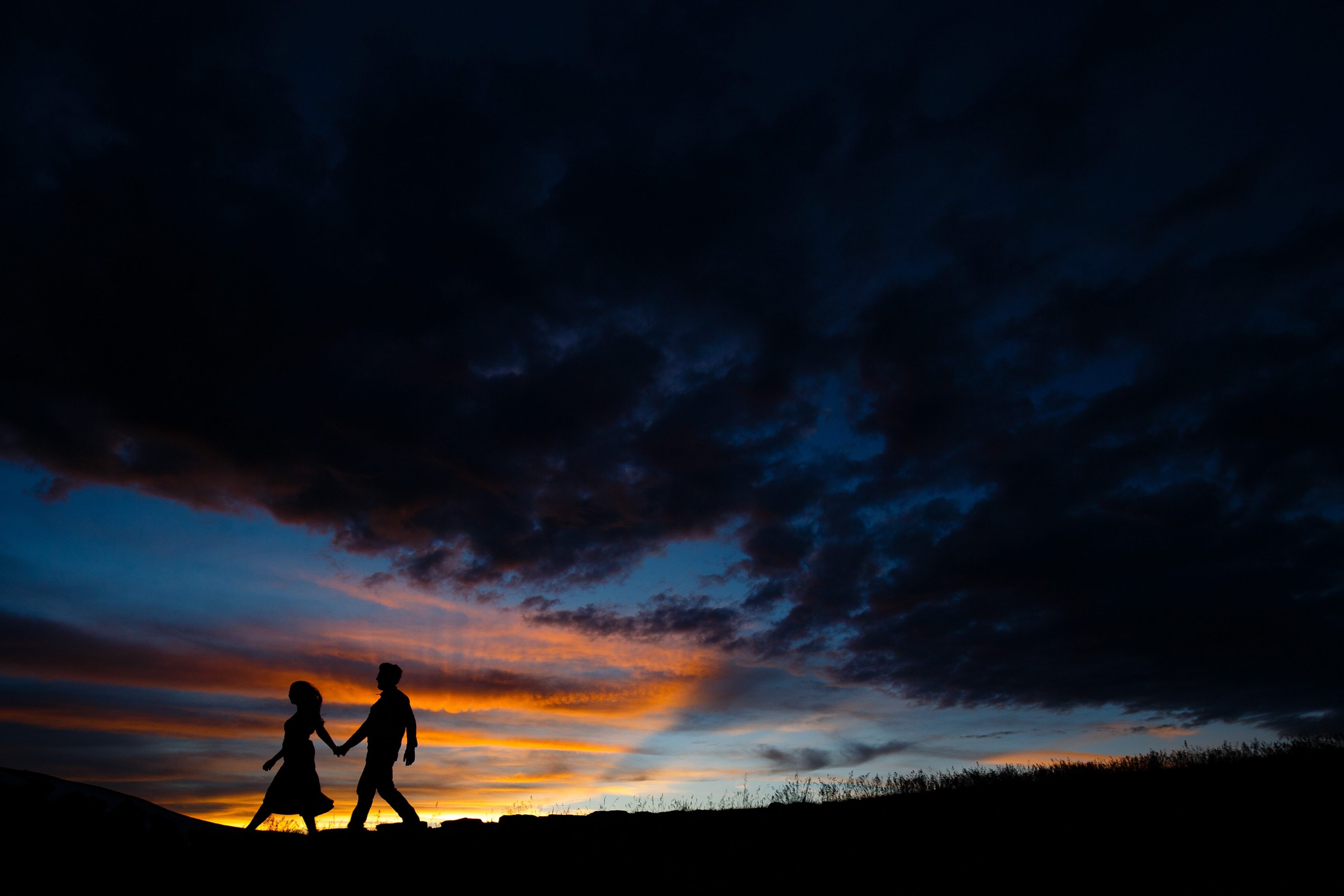 Mallory and Daniel are silhouetted against the setting Colorado sky atop Loveland Pass during their July engagement session