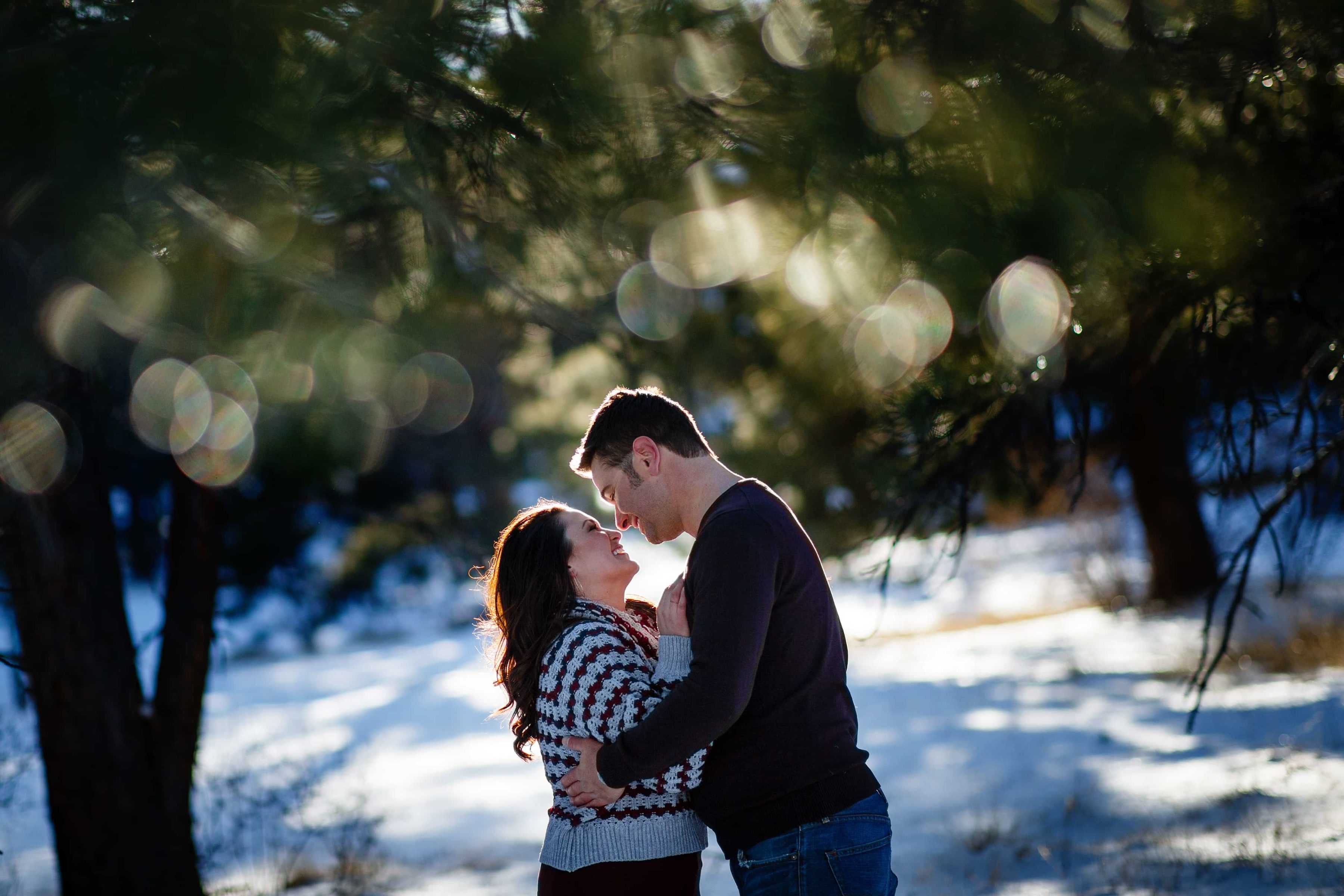 Melissa and Jordan embrage during their Elk Meadow Park winter engagement session near Evergreen, Colorado