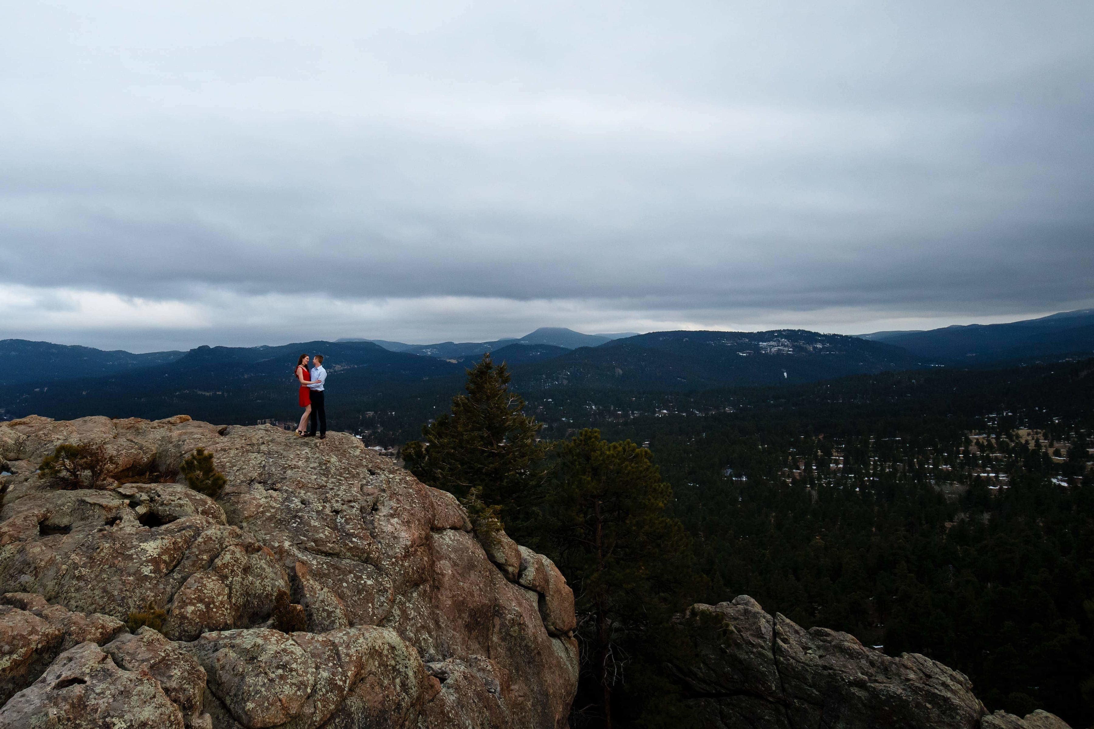 A couple pose on Brother's Lookout at Alderfer Three Sister's Park during their Evergreen engagement photos