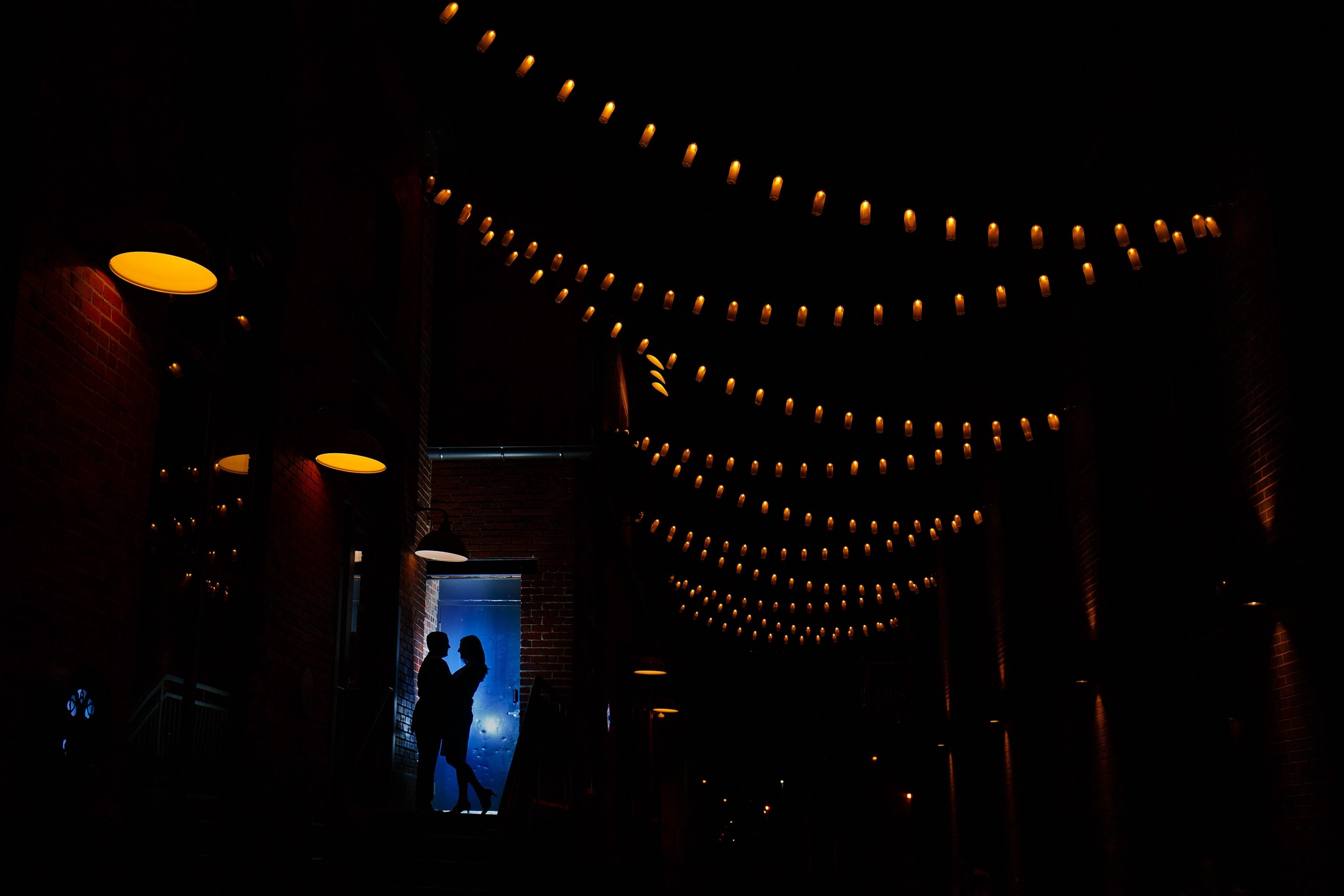 Joel and Katie share a moment together at The Dairy Block at night in downtown Denver during their spring engagement photos
