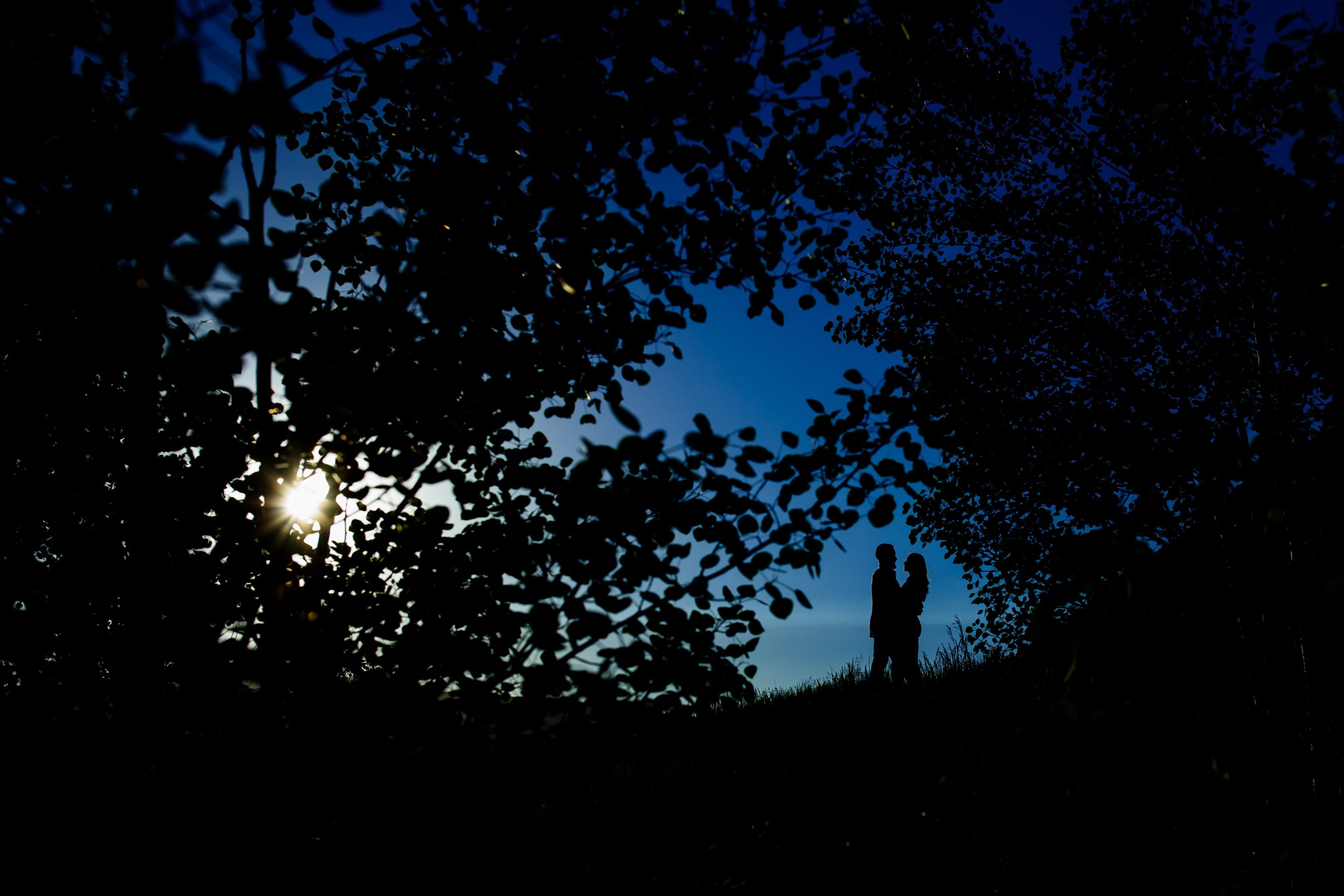 Sharon and Nick are silhouetted against the blue sky during their colorful engagement in Golden Gate Canyon State Park