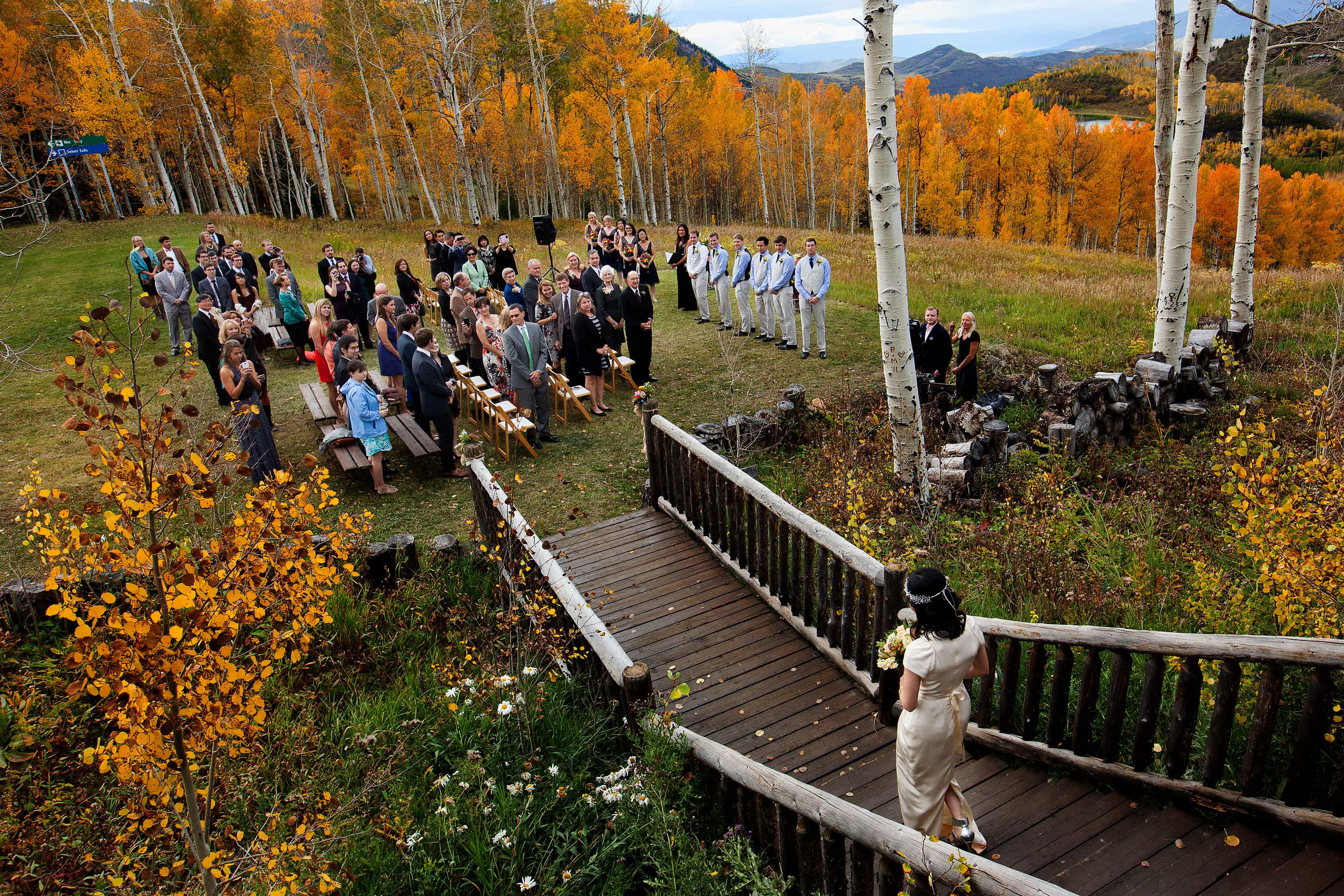A bride walks out of Lynn Britt cabin during her wedding in Snowmass Colorado