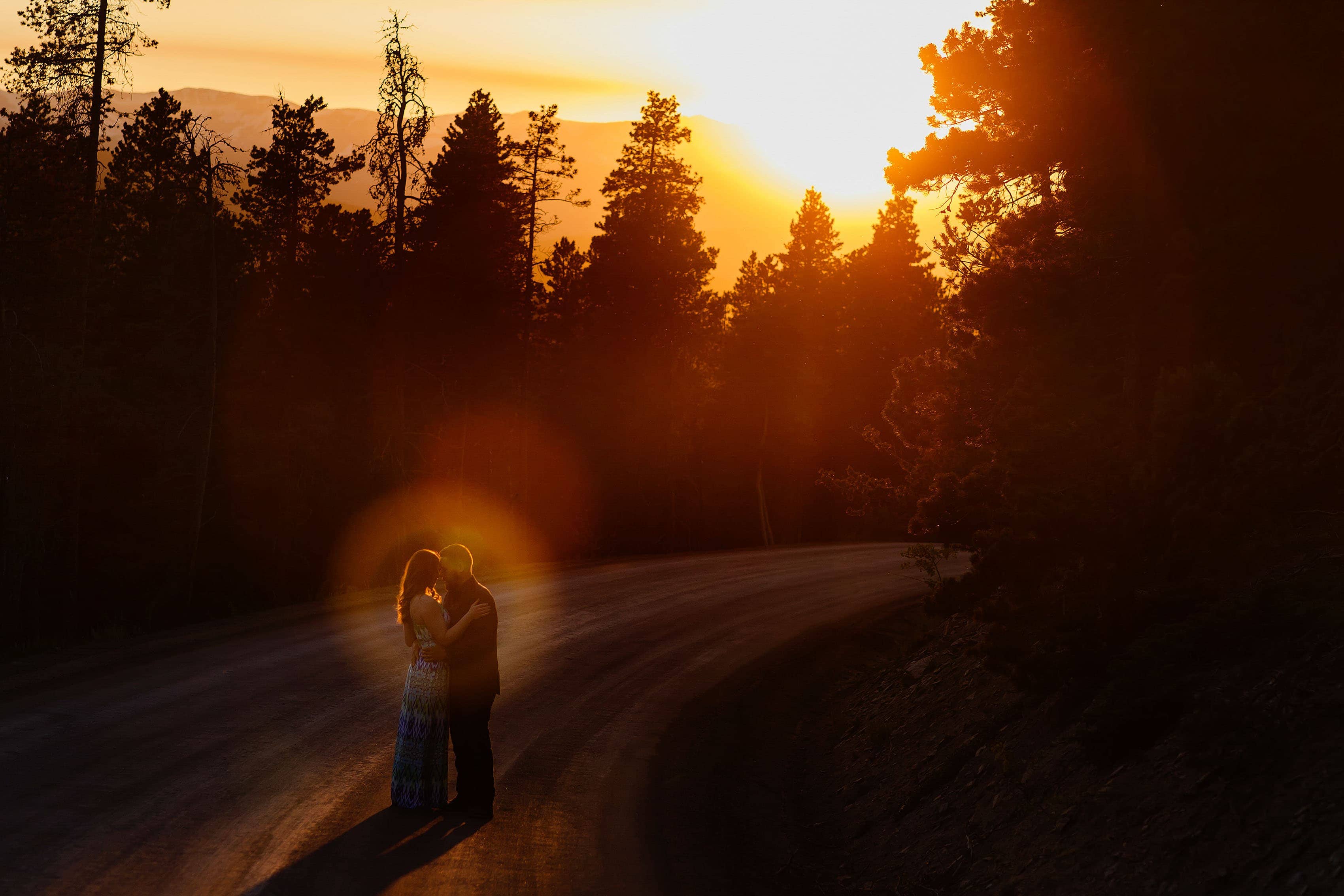 A couple embraces on Gap Road in Golden during their engagement session at sunset