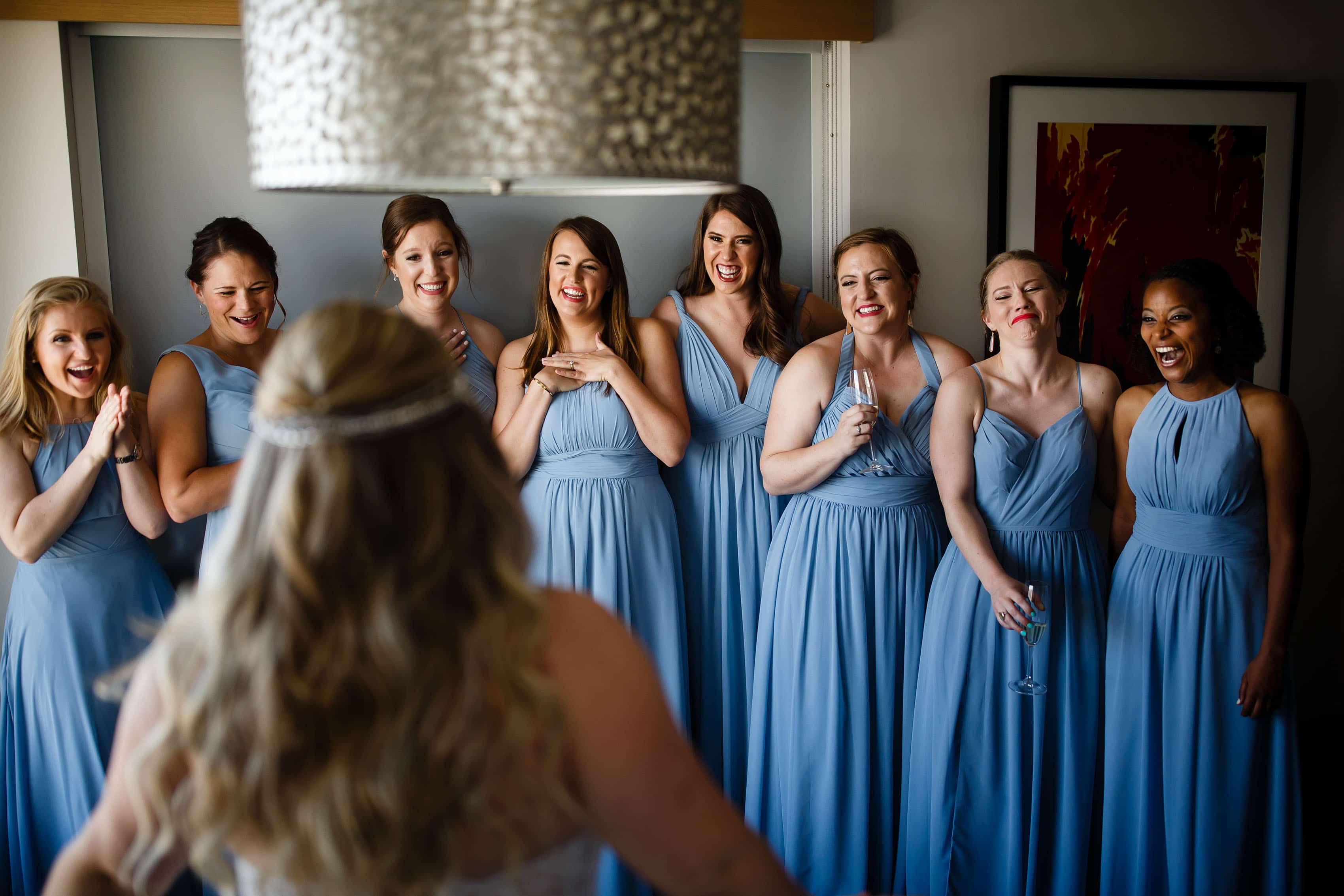 Bridesmaids react to seeing the bride in her dress at the Art Hotel in Denver