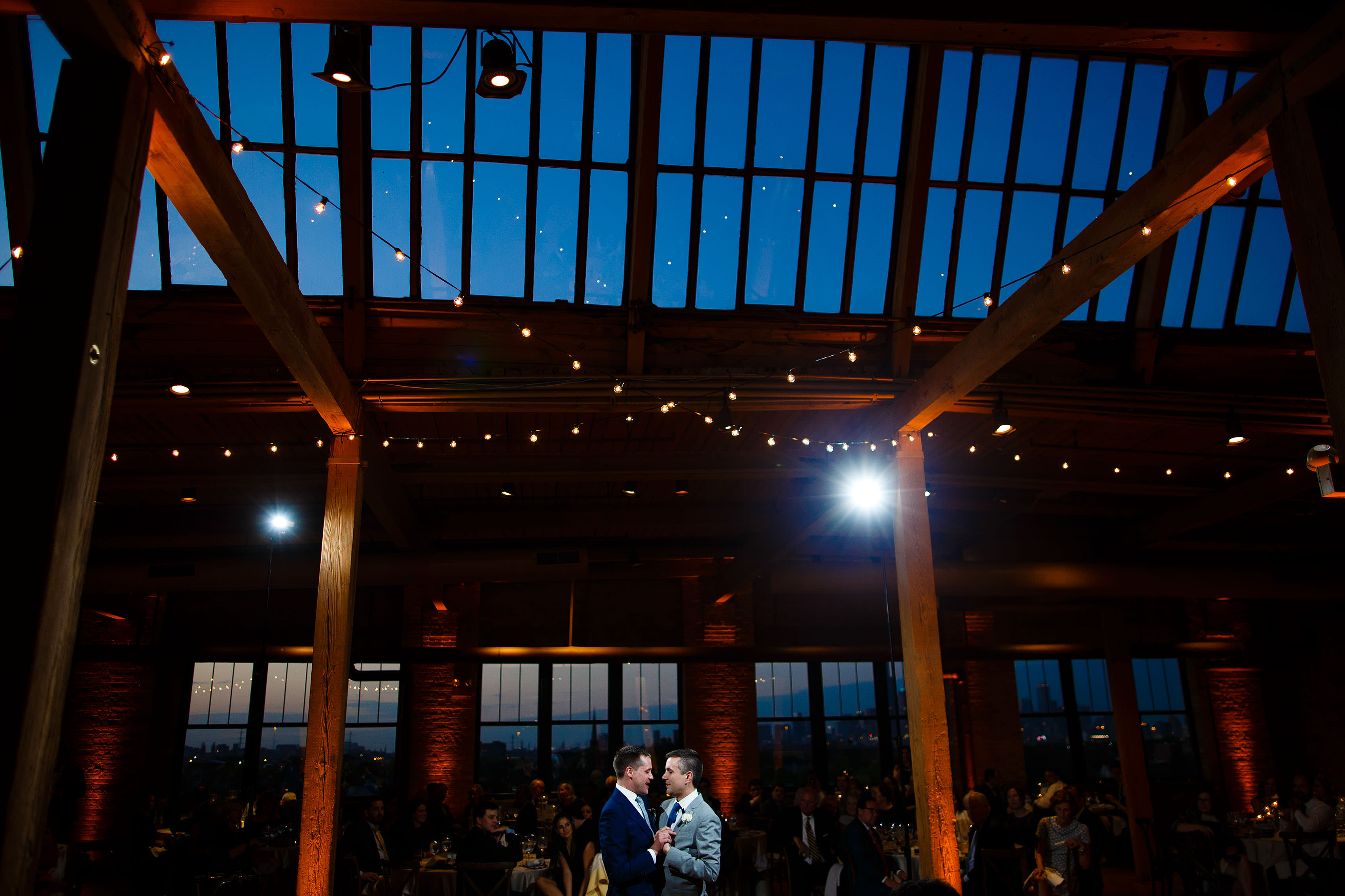 The grooms share a first dance during twilight at their Bridgeport Art Center wedding in Chicago