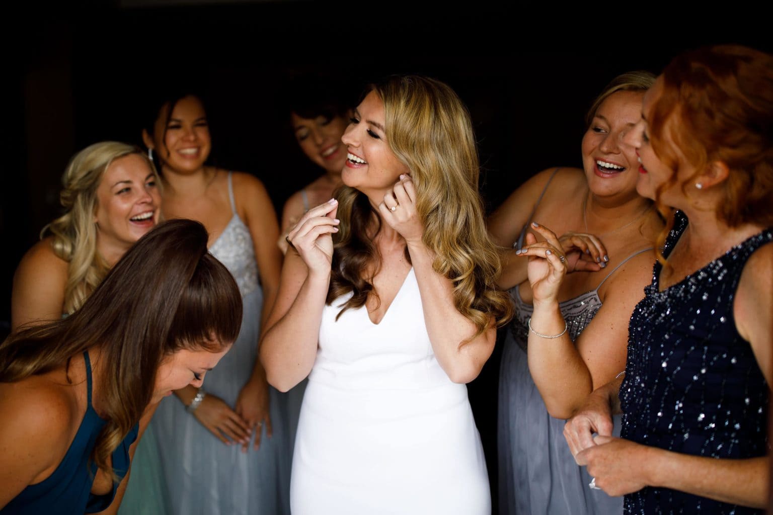 The bride puts on earrings with bridesmaids in Breckenridge