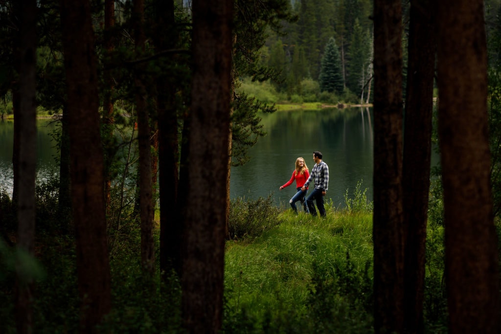 A couple walk together on a trail during their engagement session at Officer's Gulch