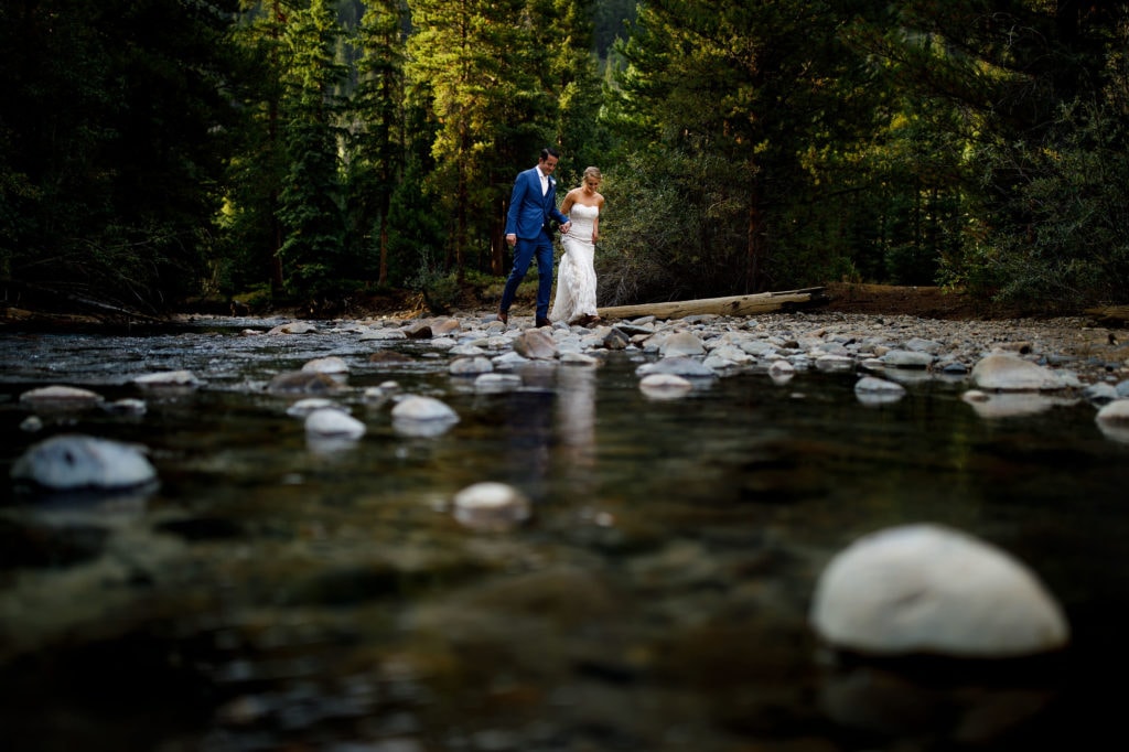 A couple walk together along the Snake River during their summer Keystone wedding