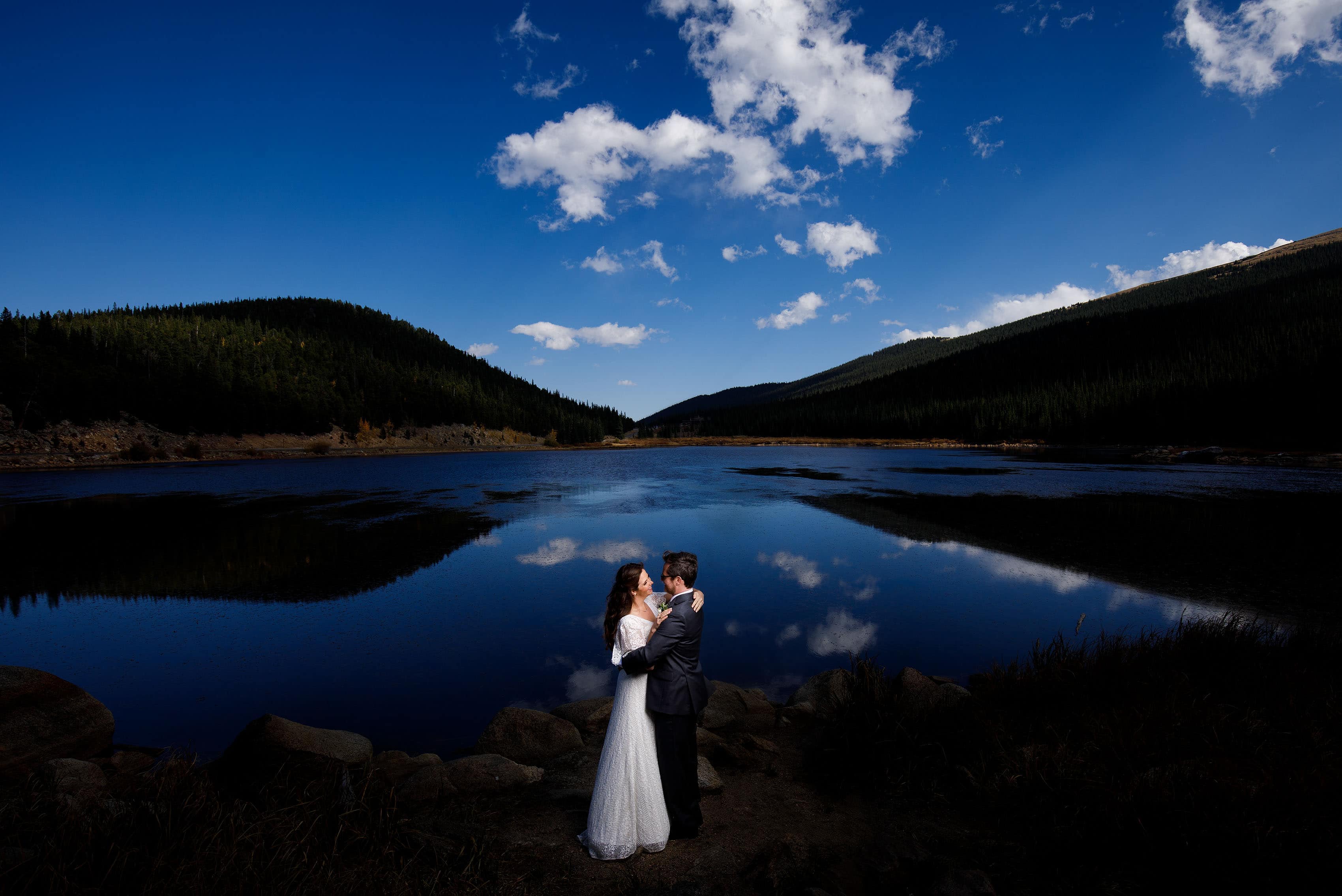 The couple poses at Echo Lake near Mount Evans after their fall Blackstone Rivers Ranch wedding in Idaho Springs Colorado