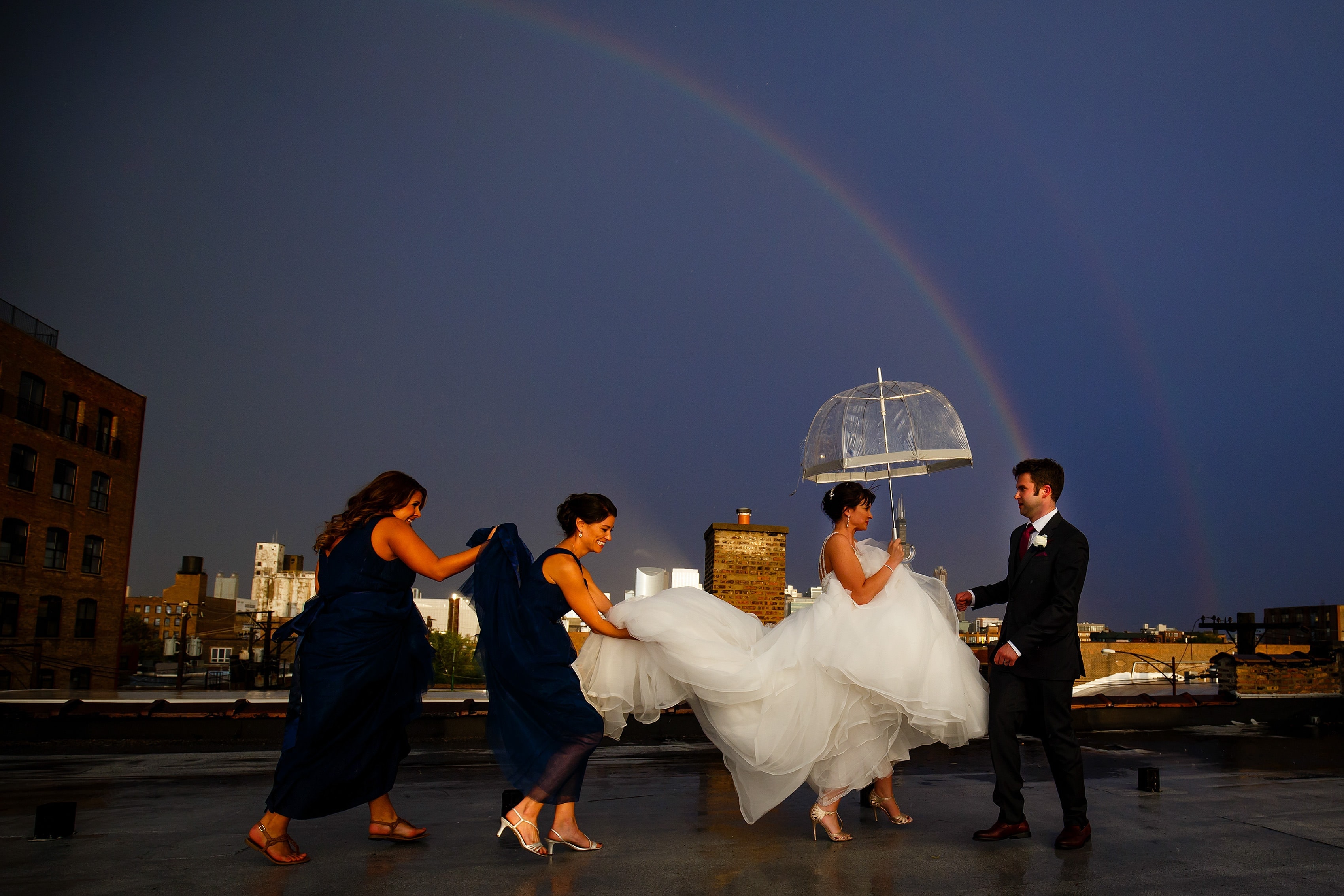 Chelsea gets some help with her dress on the rooftop above Room 1520 as rain falls and a rainbow is emerges in the sky
