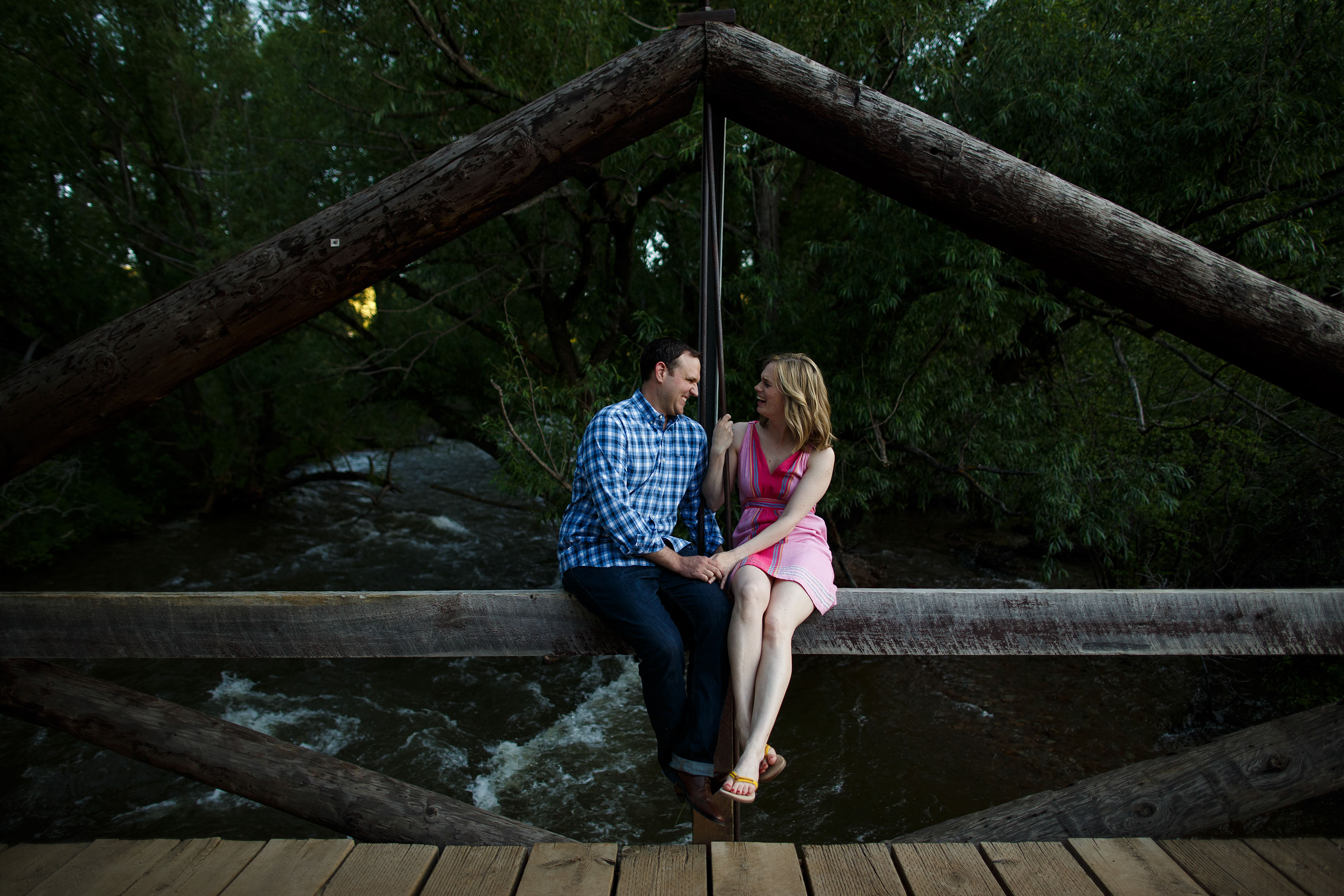 A couple sit on the bridge over South Boulder Creek at the South Mesa Trailhead in Eldorado Springs