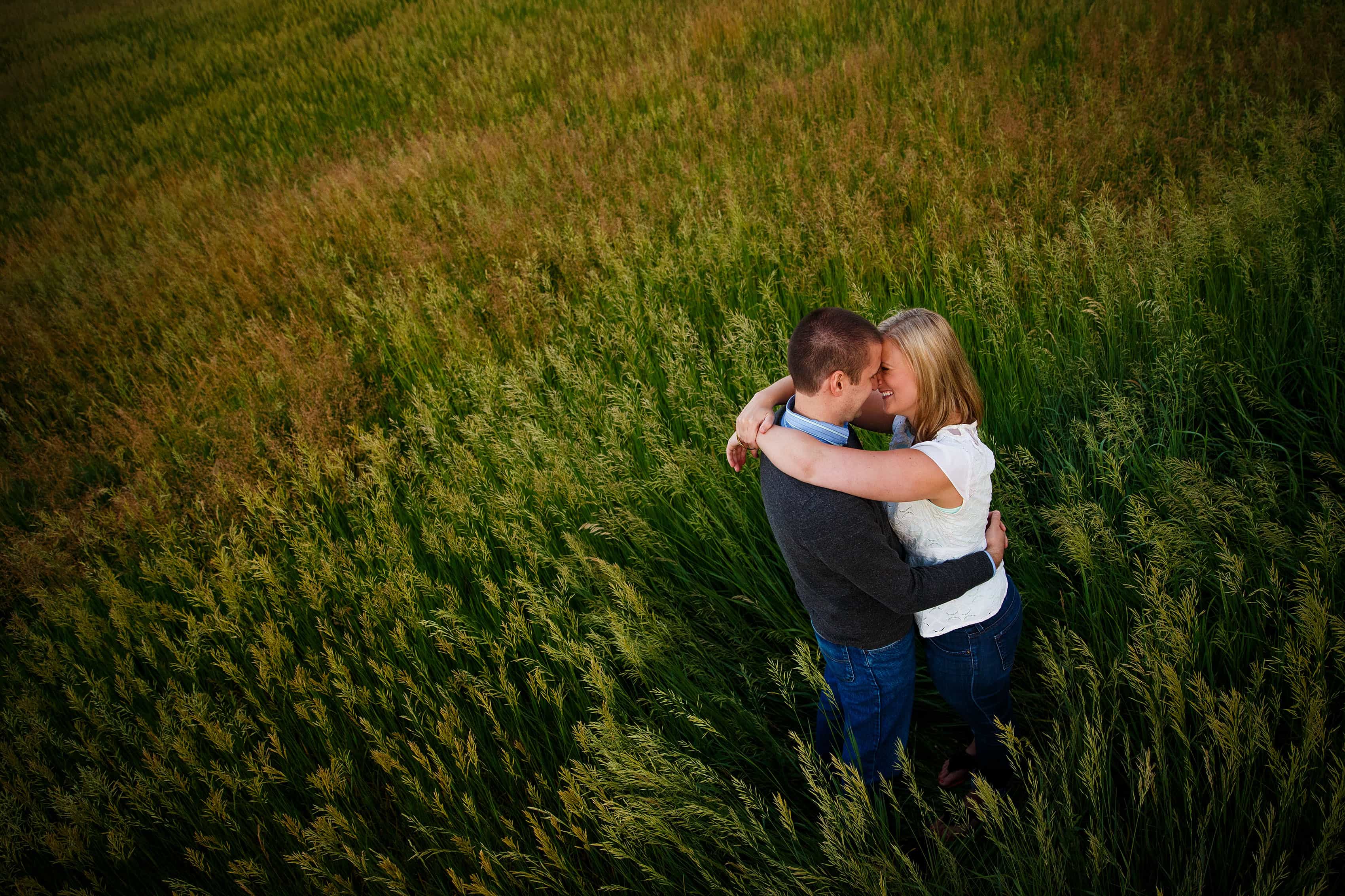 Ross hugs Emily at Roxborough State Park in a meadow during their engagement photos