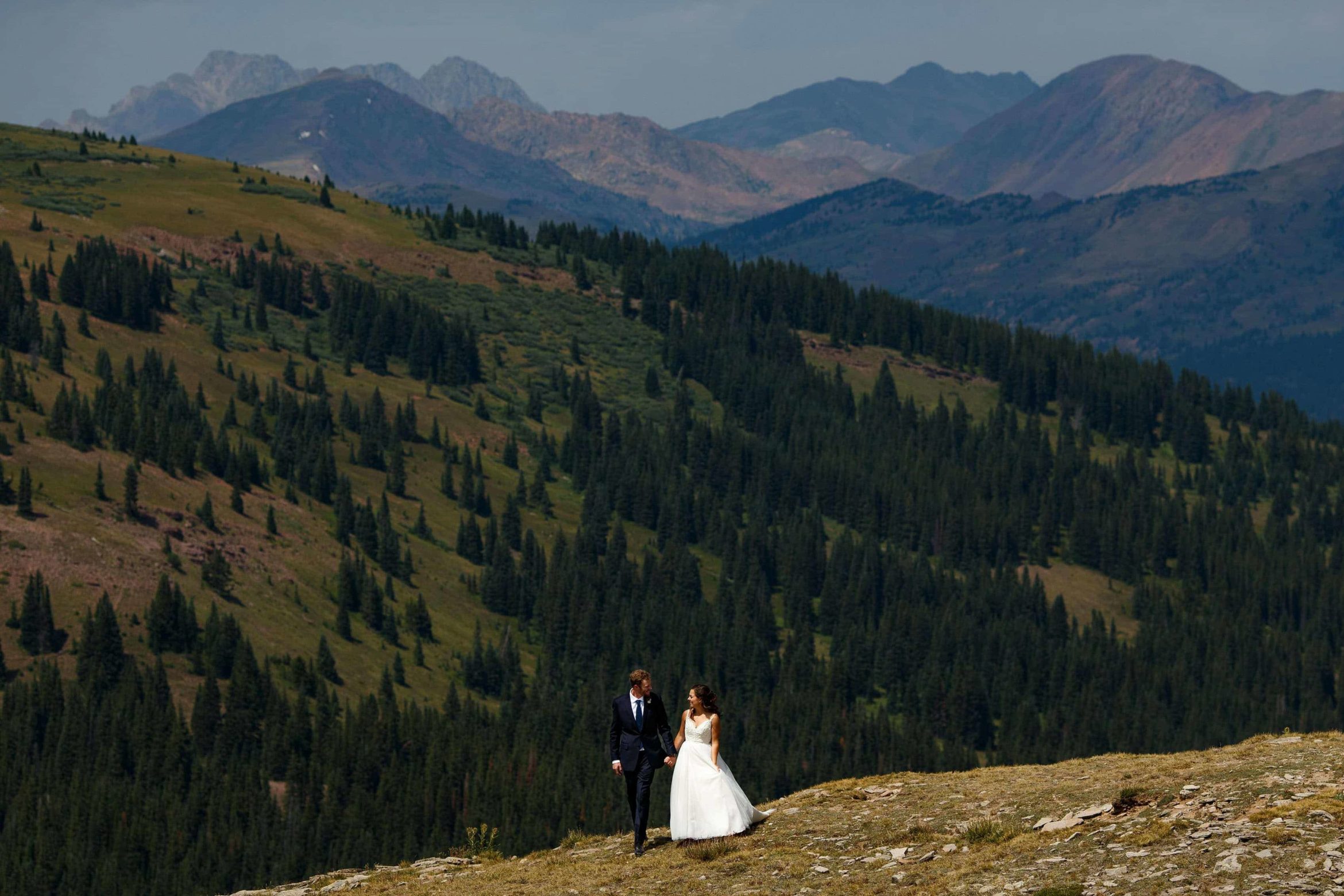 Newlyweds walk on the top of Ptarmigan Pass during their Camp Hale wedding