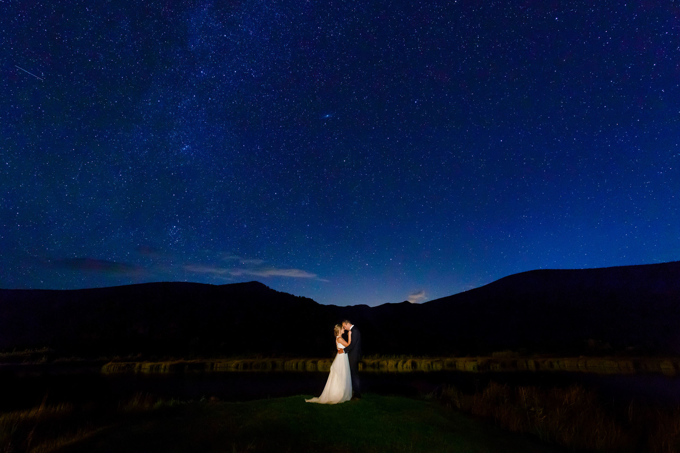 Meghan and Kevin embrace under the stars during their fall wedding at Camp Hale in Colorado
