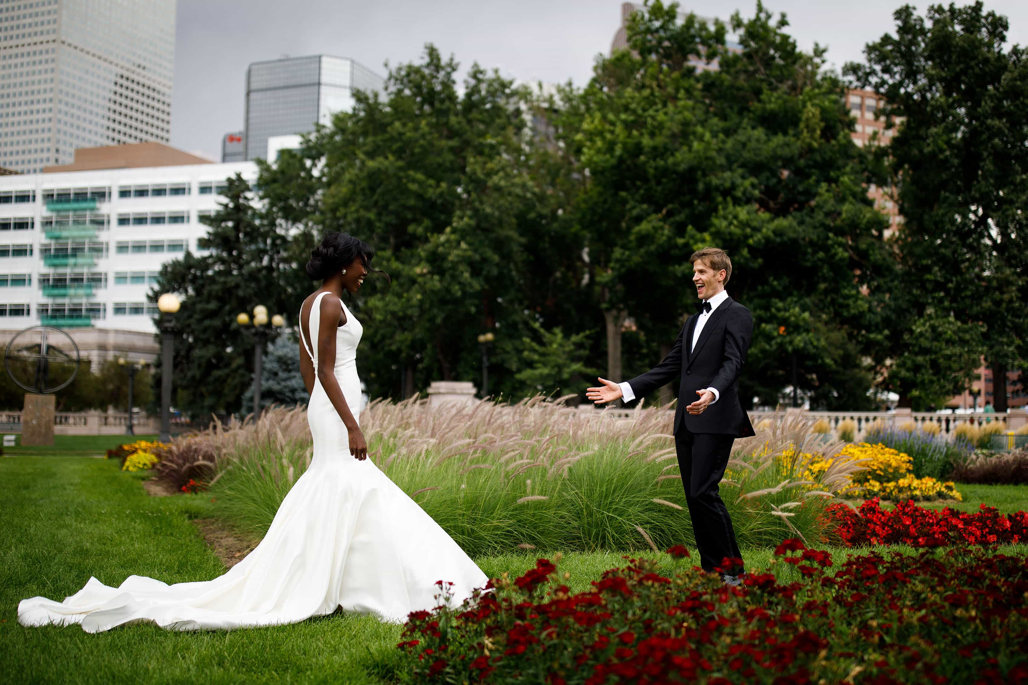 A couple react during their first look in Civic Center Park on their wedding day