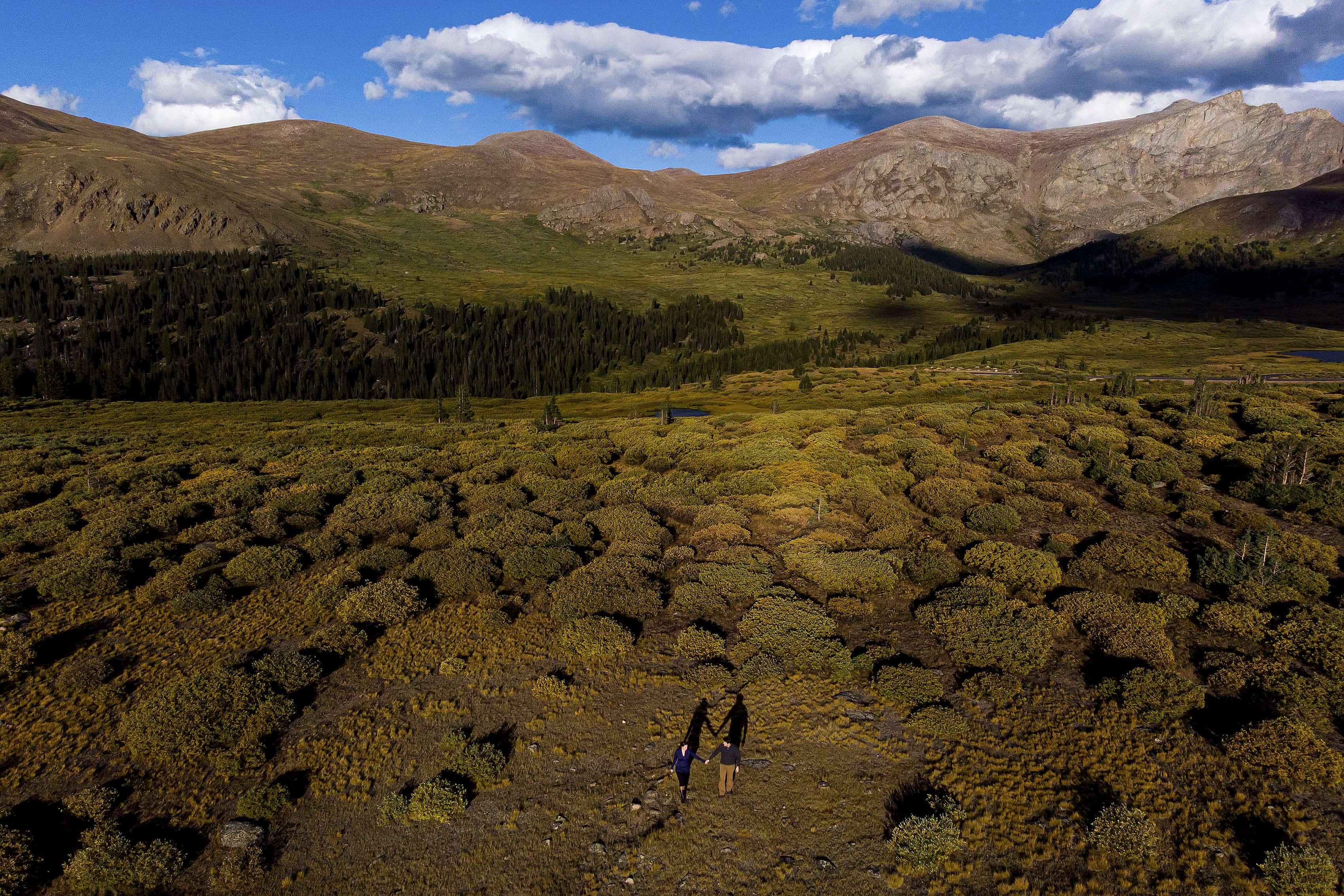 An arial drone photo of a couple walking together at Guanella Pass during their fall engagement session in Colorado