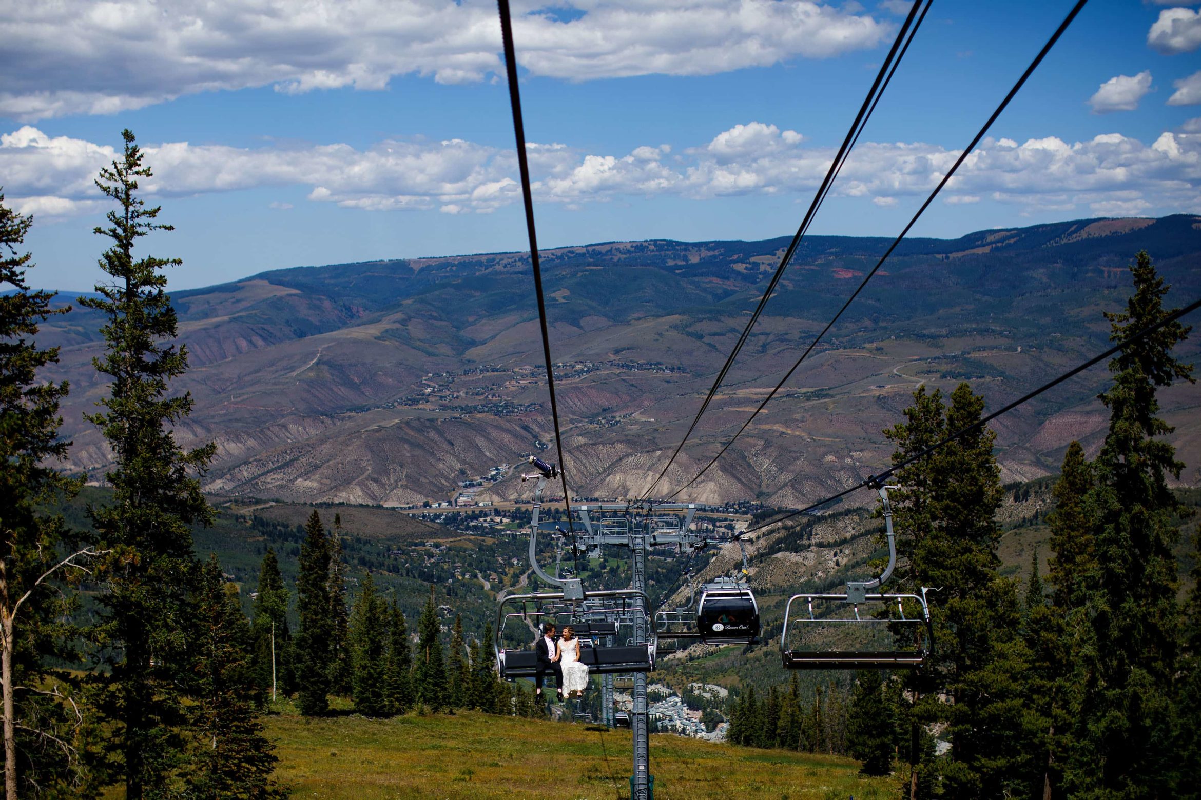 The bride and groom ride the Centennial Express chairlift on their wedding day in Beaver Creek