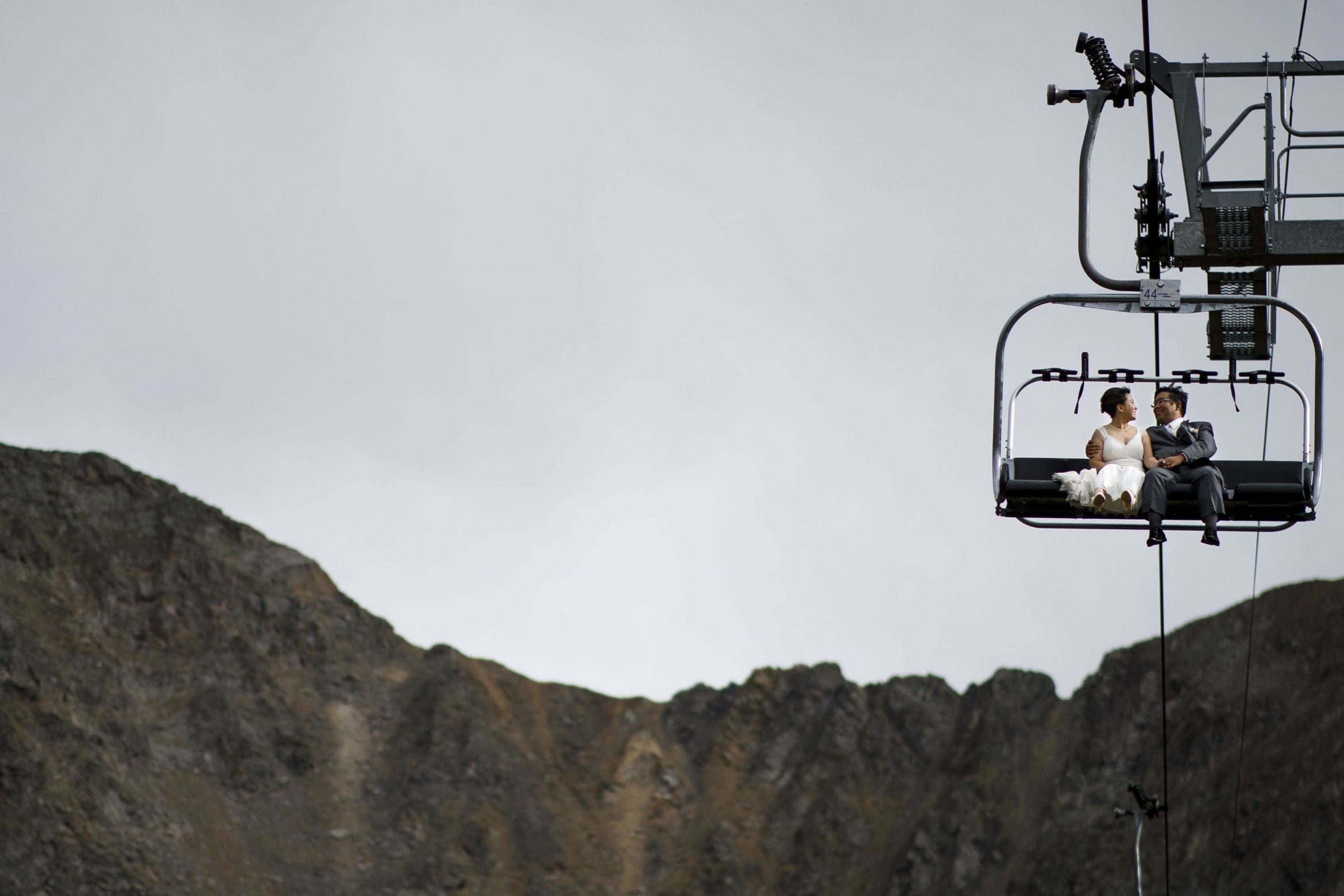 A couple ride the Black Mountain Express chairlift at A Basin on their wedding day