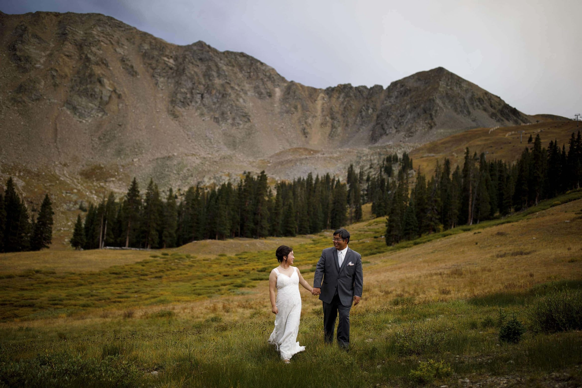 David and Xinya walks together in the field near the East Wall at A Basin during their wedding