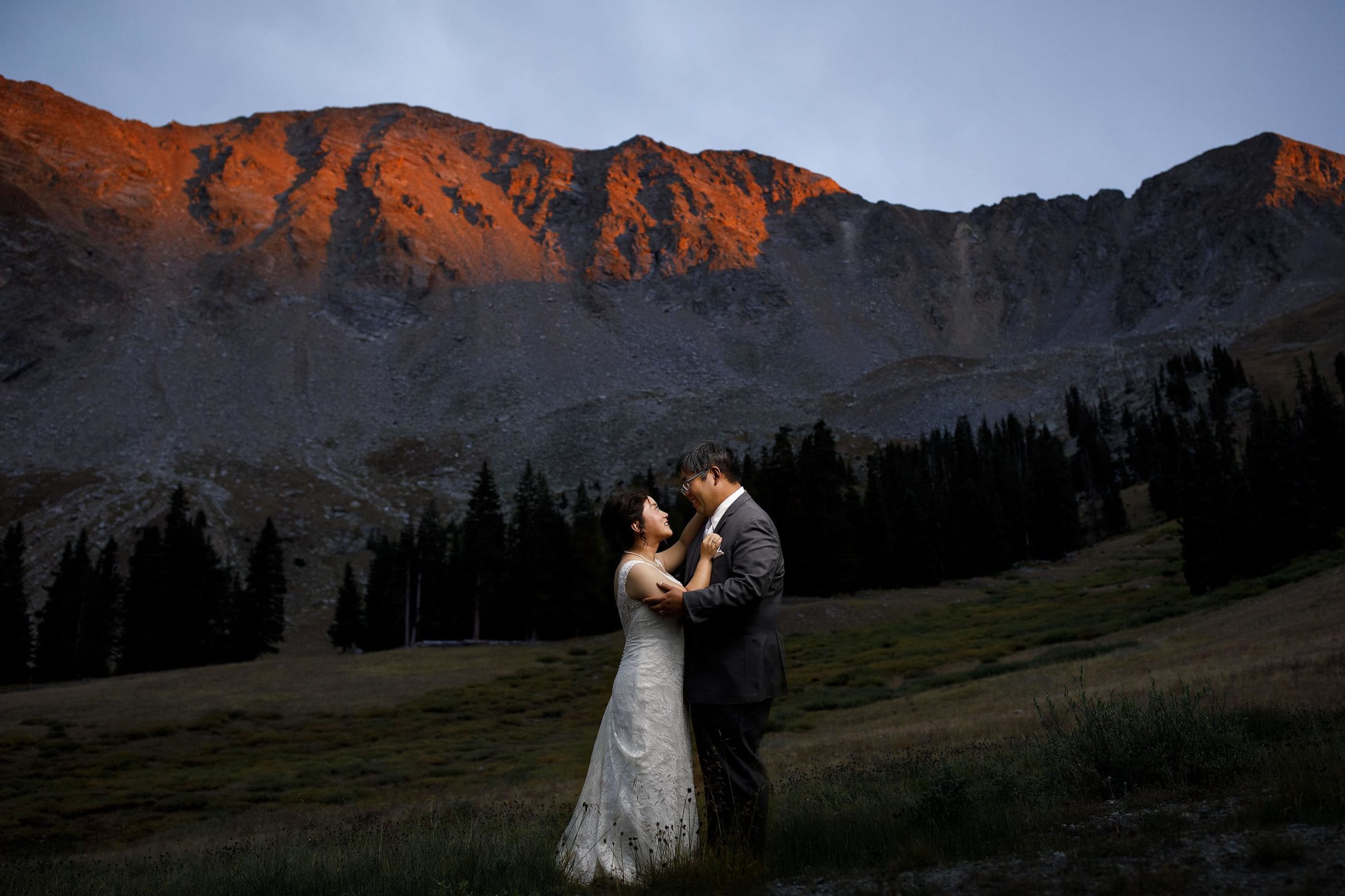 A couple share a moment together as alpenglow hits the East Wall at Arapahoe Basin on their wedding day