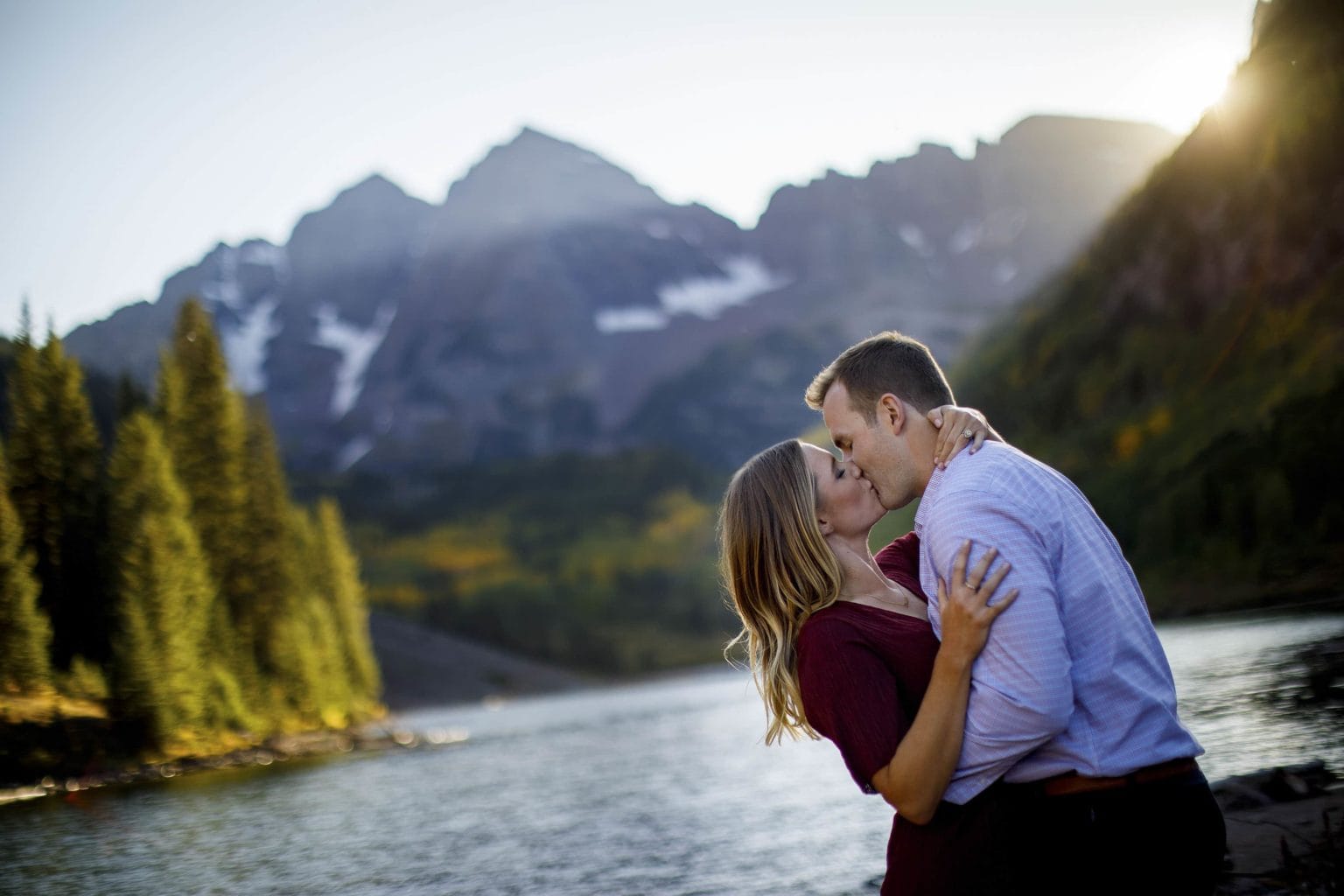 A couple share a kiss as the sun sets behind the Maroon Bells in Aspen in late September