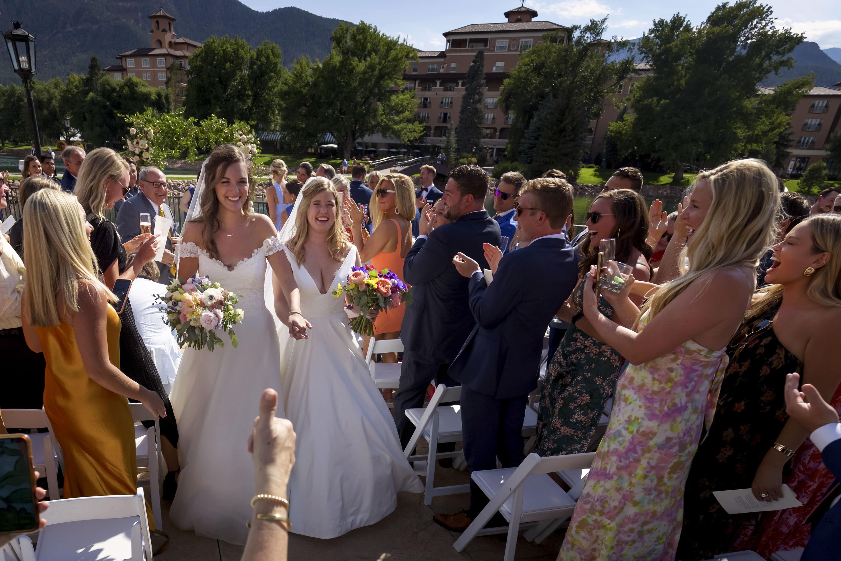 Newlywed brides walk down the aisle following their wedding ceremony at The Broadmoor in Colorado Springs