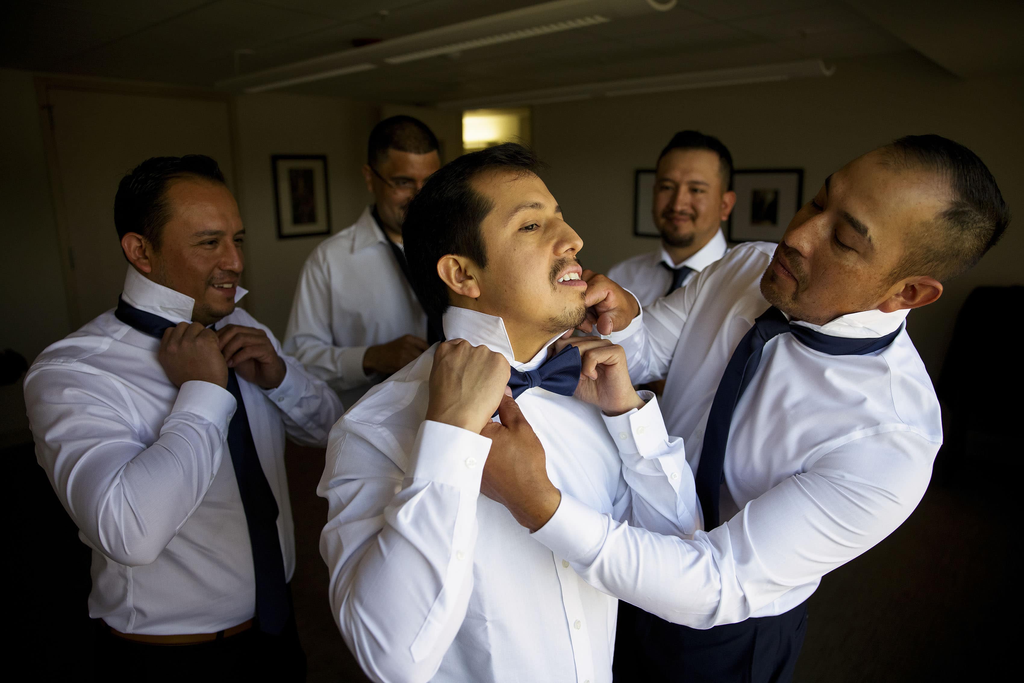 Eddy gets some help with his tie by one of his brothers before the wedding ceremony