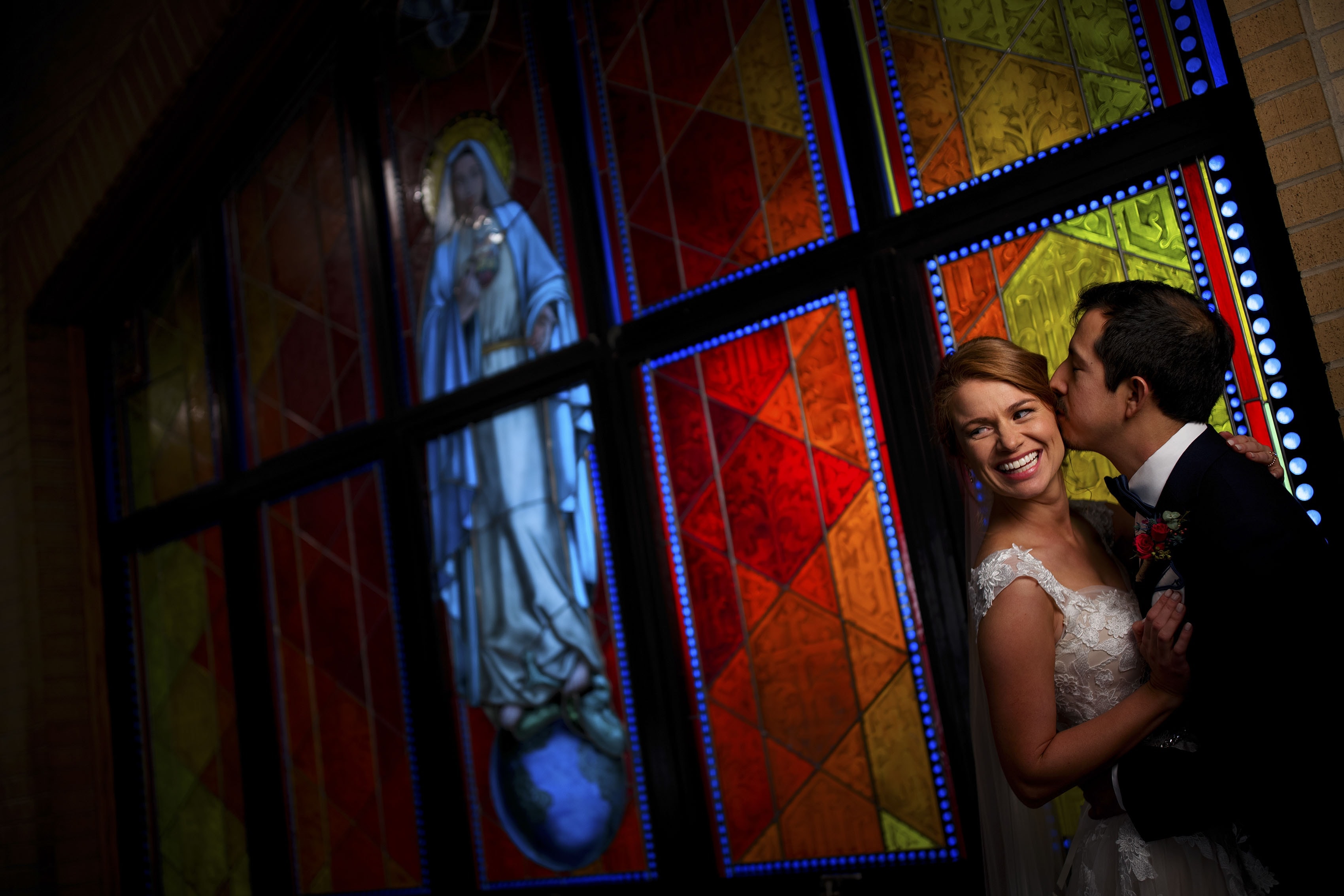 Makena and Eddy pose in Holy Name Catholic Church on their wedding day