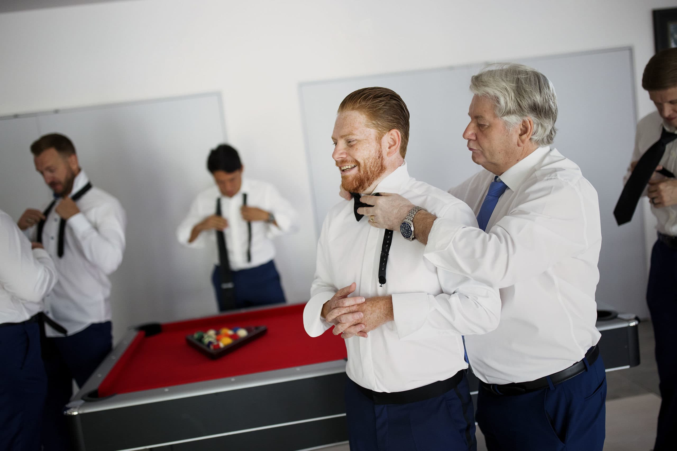 The groom gets some help with his tie