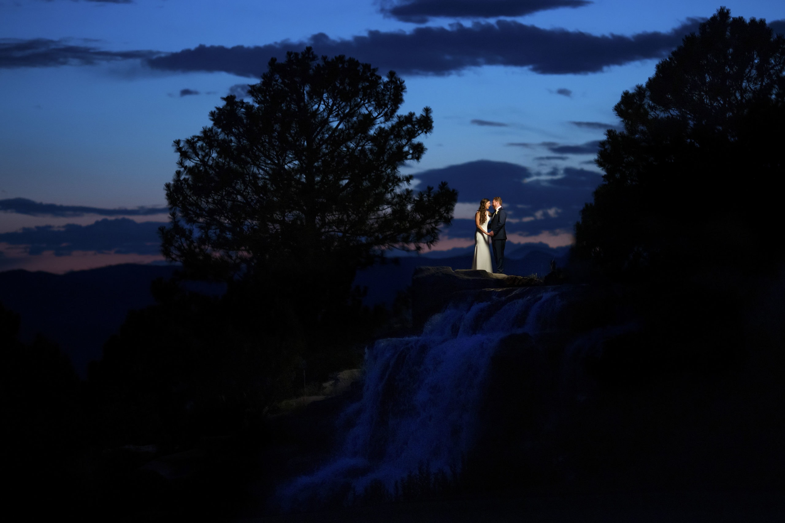 A married couple poses on the waterfall near the 18th hole at Sanctuary Golf Course