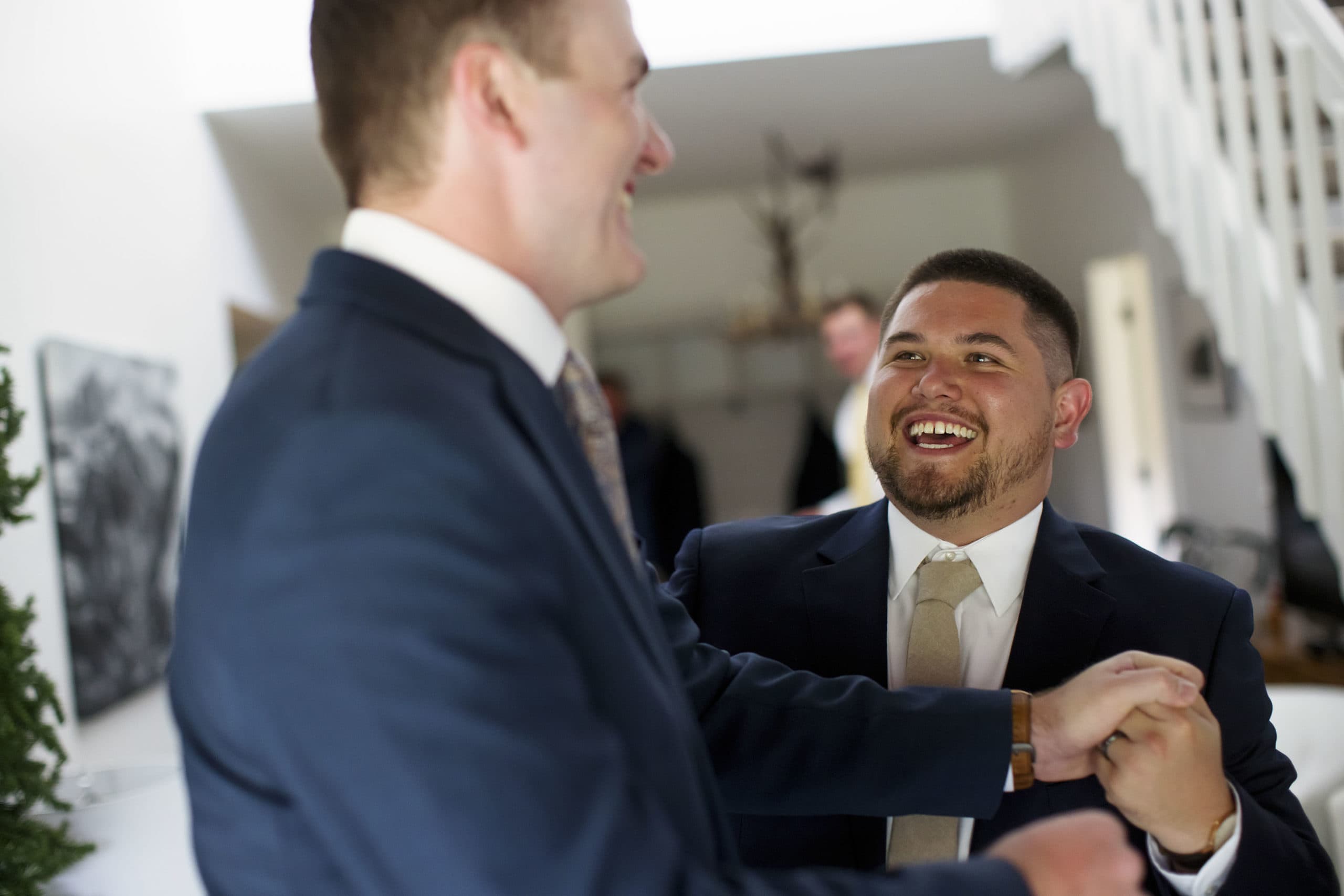 The groom and best man share a laugh while getting ready