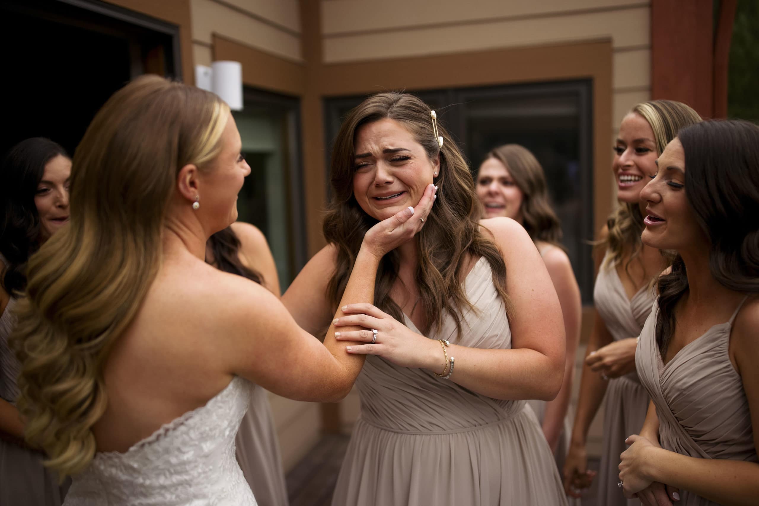 A bridesmaid cries as the bride comforts her