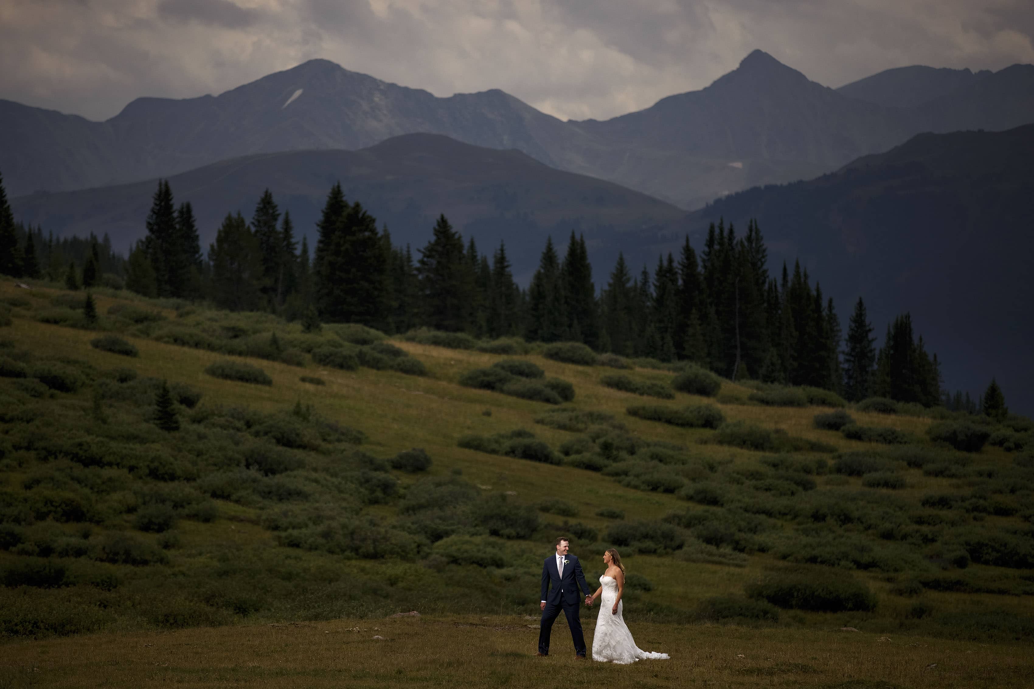 The bride and groom pose for a portrait on Shrine Pass with the Tenmile range in the background