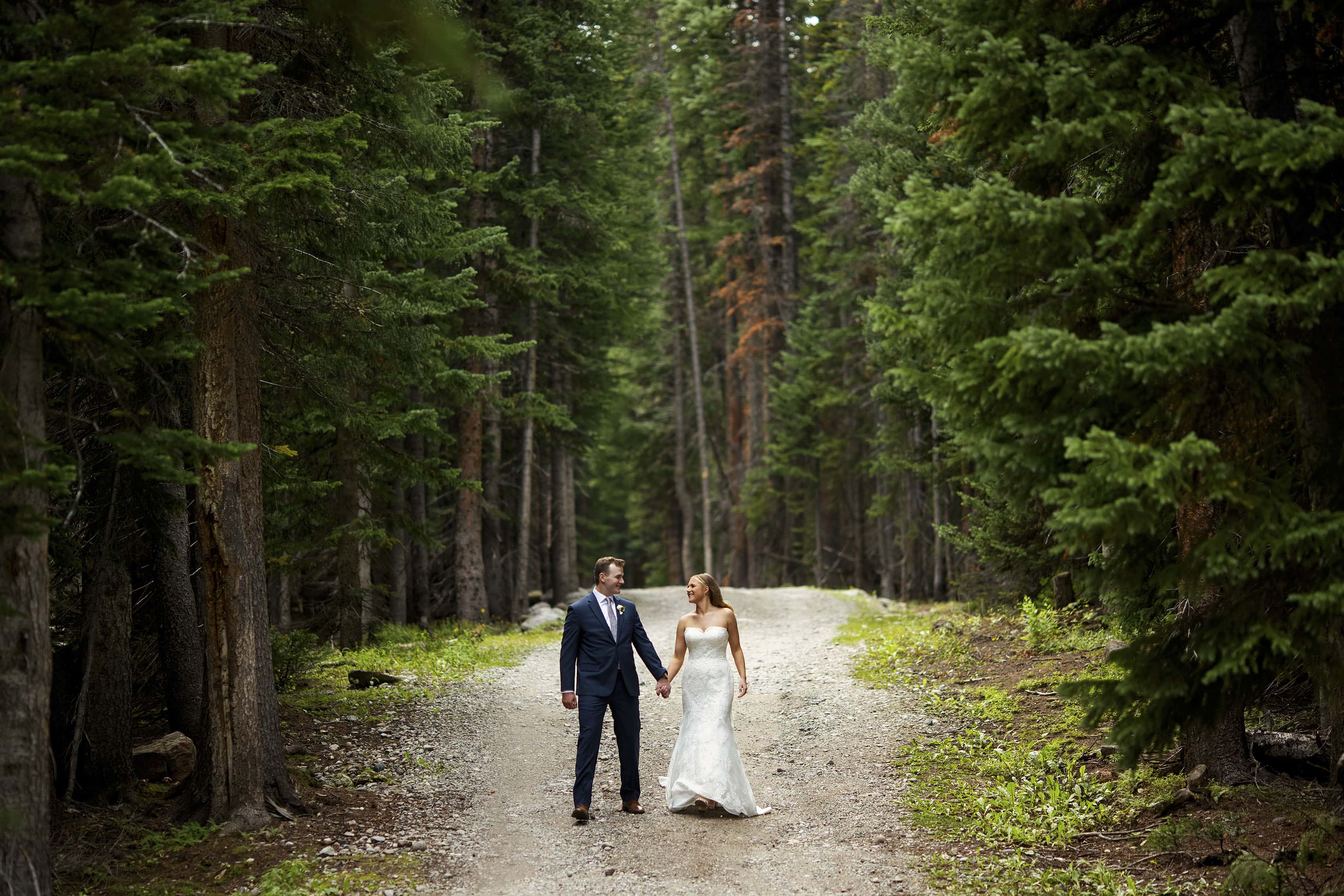 The groom and bride walk together along the road on Shrine Pass