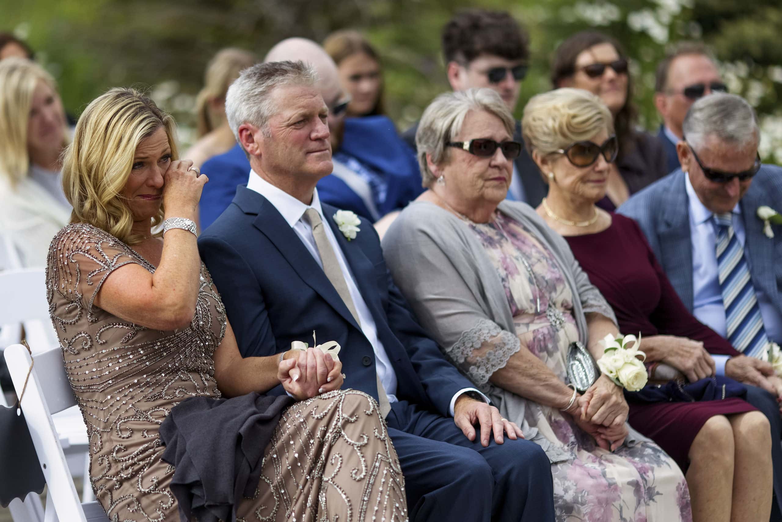 The mother of the bride wipes a tear away during the ceremony