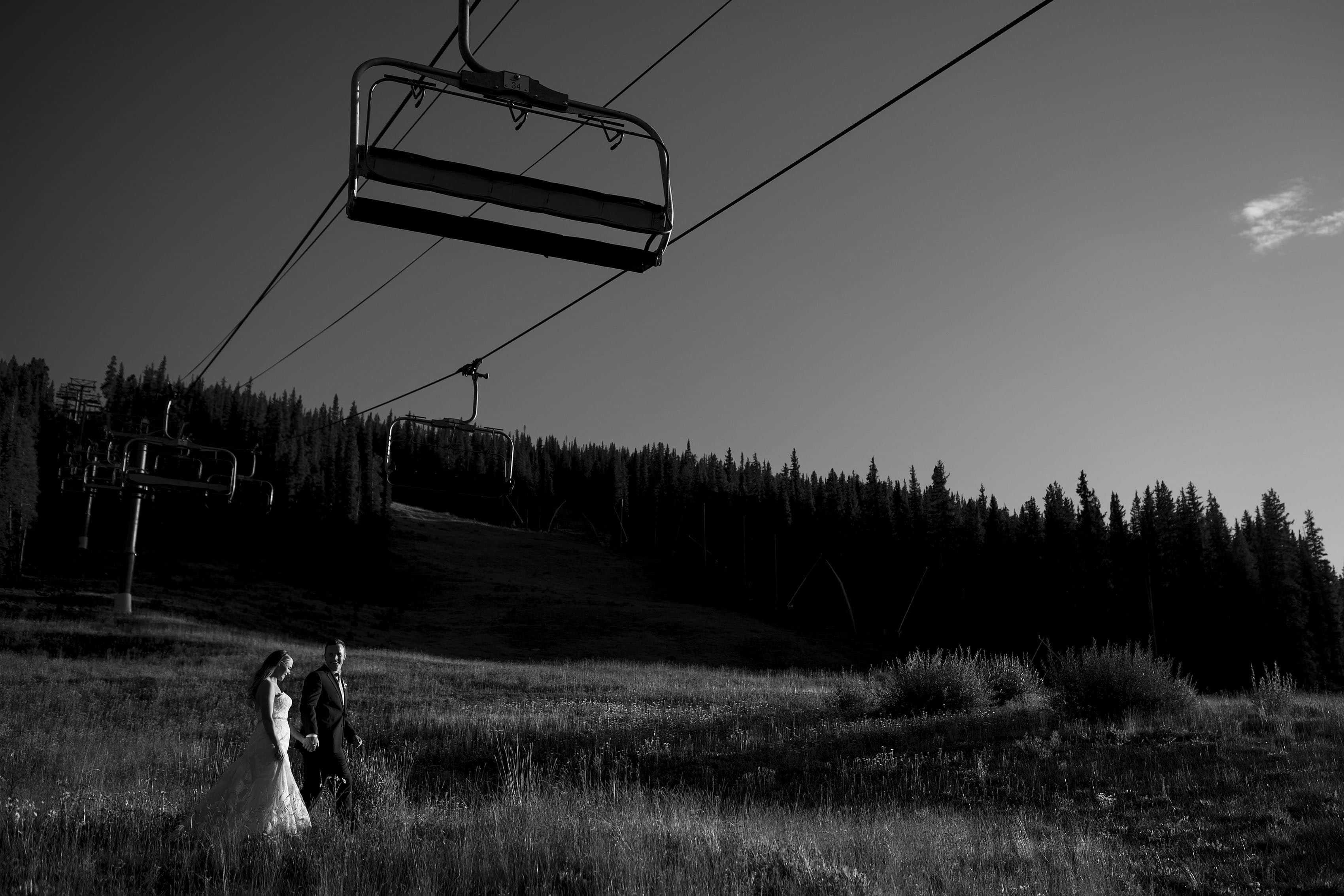 The newlyweds walk under the Super Bee lift during their wedding day at Copper Mountain