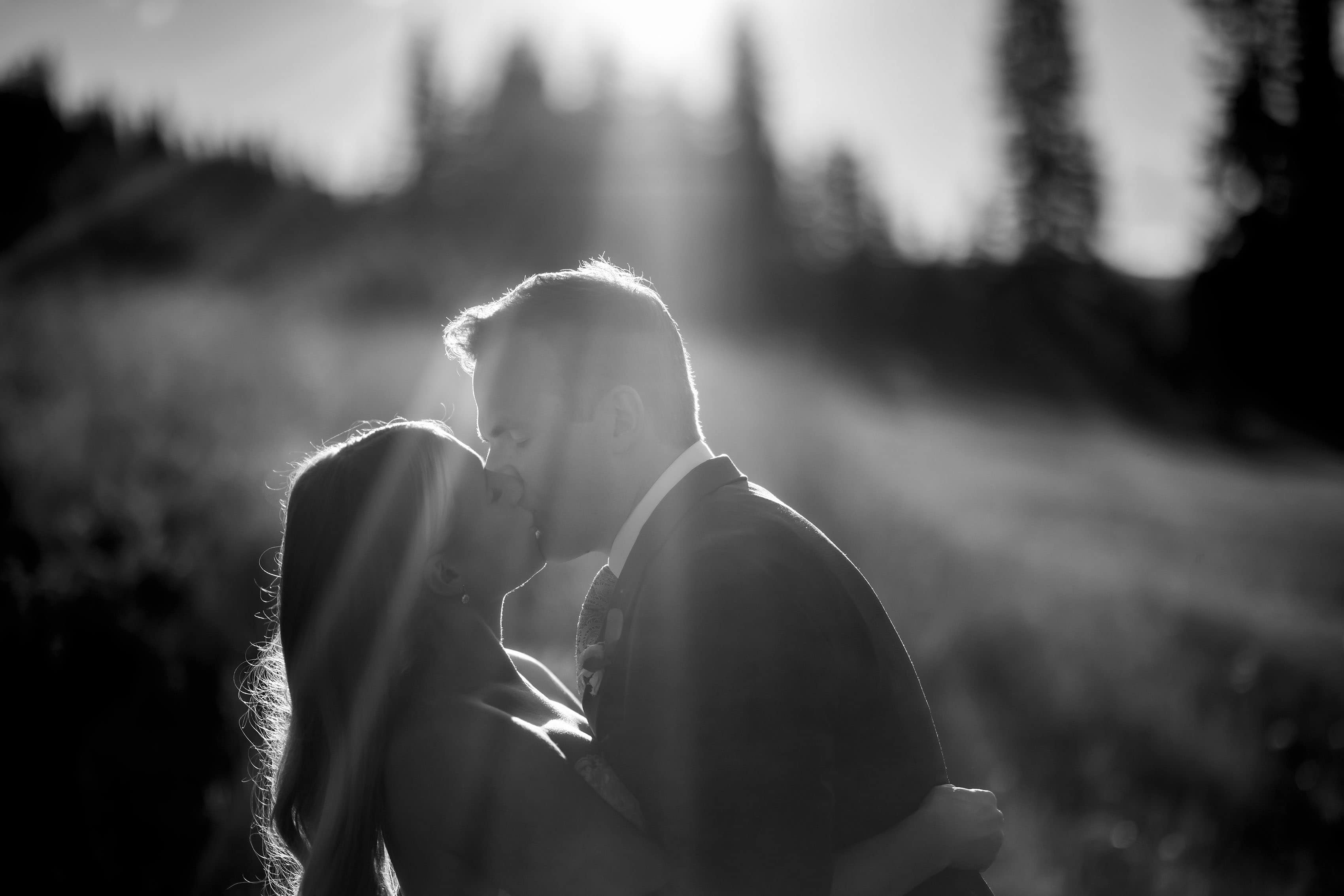 Sun rays shine past the bride and groom at Copper Mountain on their wedding day