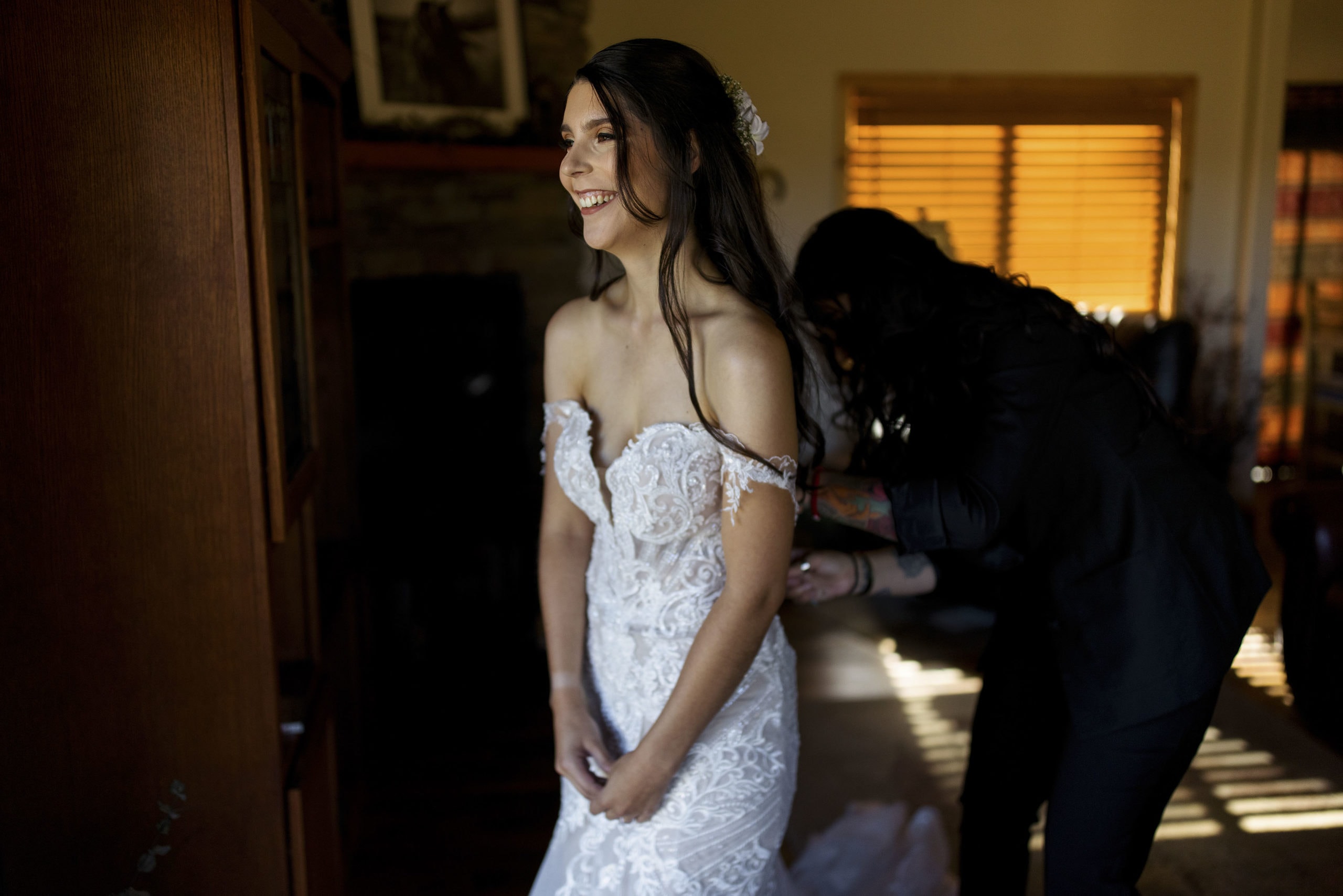 Briana gets some help from a friend as she puts her wedding dress on