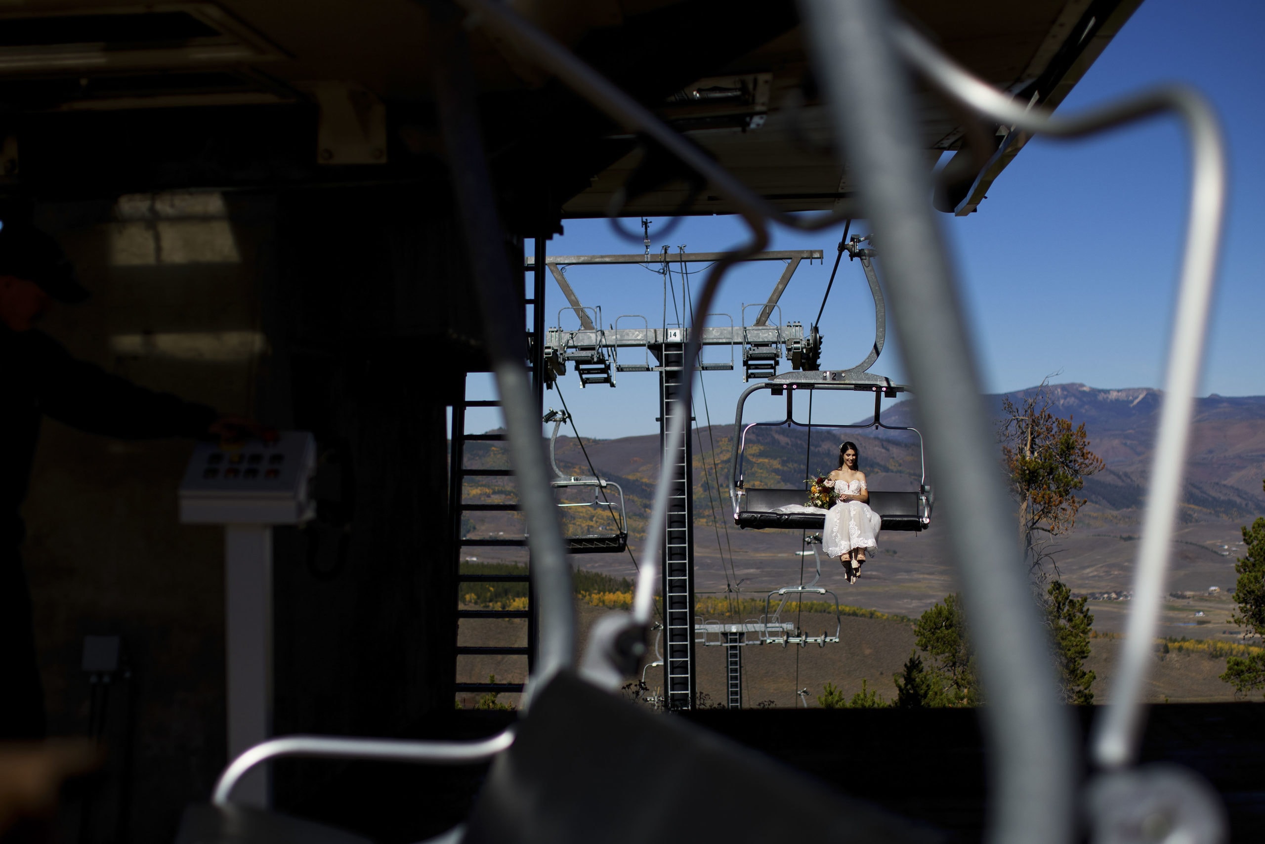 A bride rides the Quick Draw Express chairlift to the top of Granby Ranch before her fall elopement ceremony