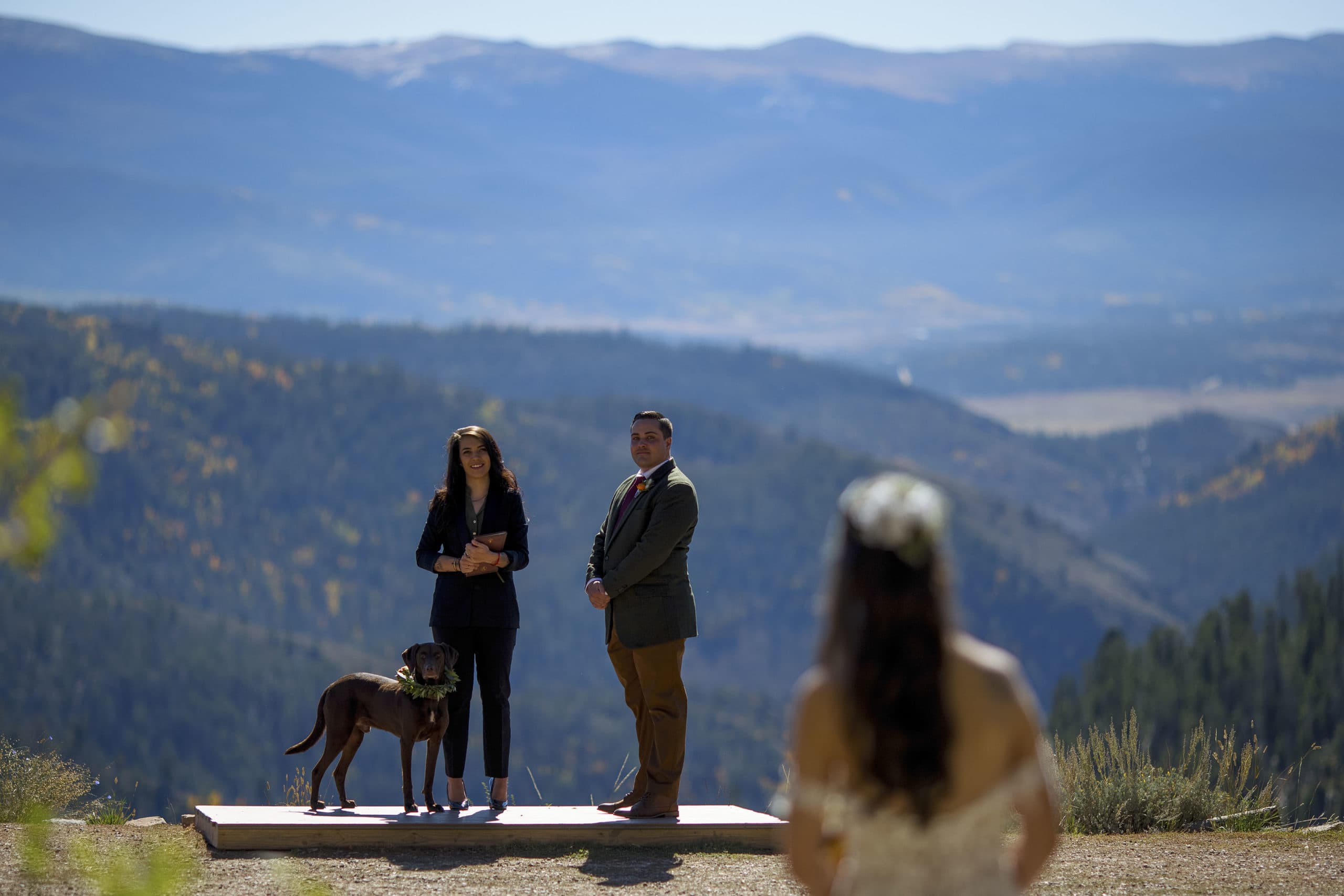 The groom, dog and officiant see the bride walk down the aisle at Granby Ranch