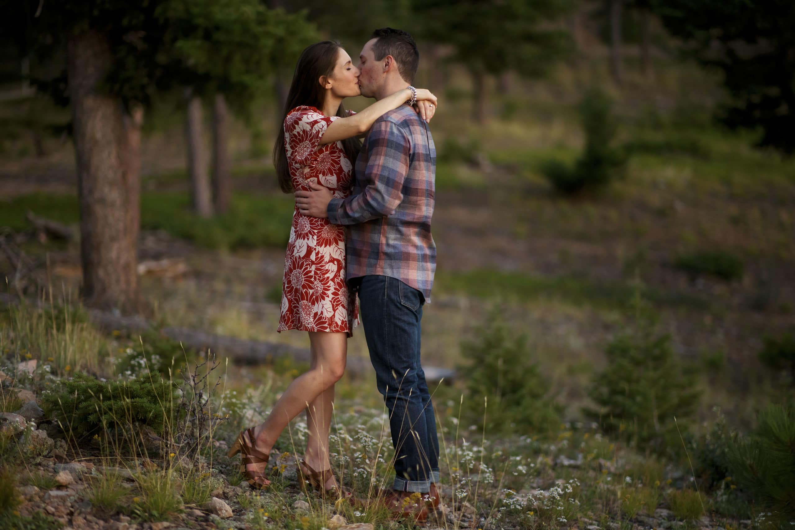 A couple shares a kiss in a grove of aspen trees