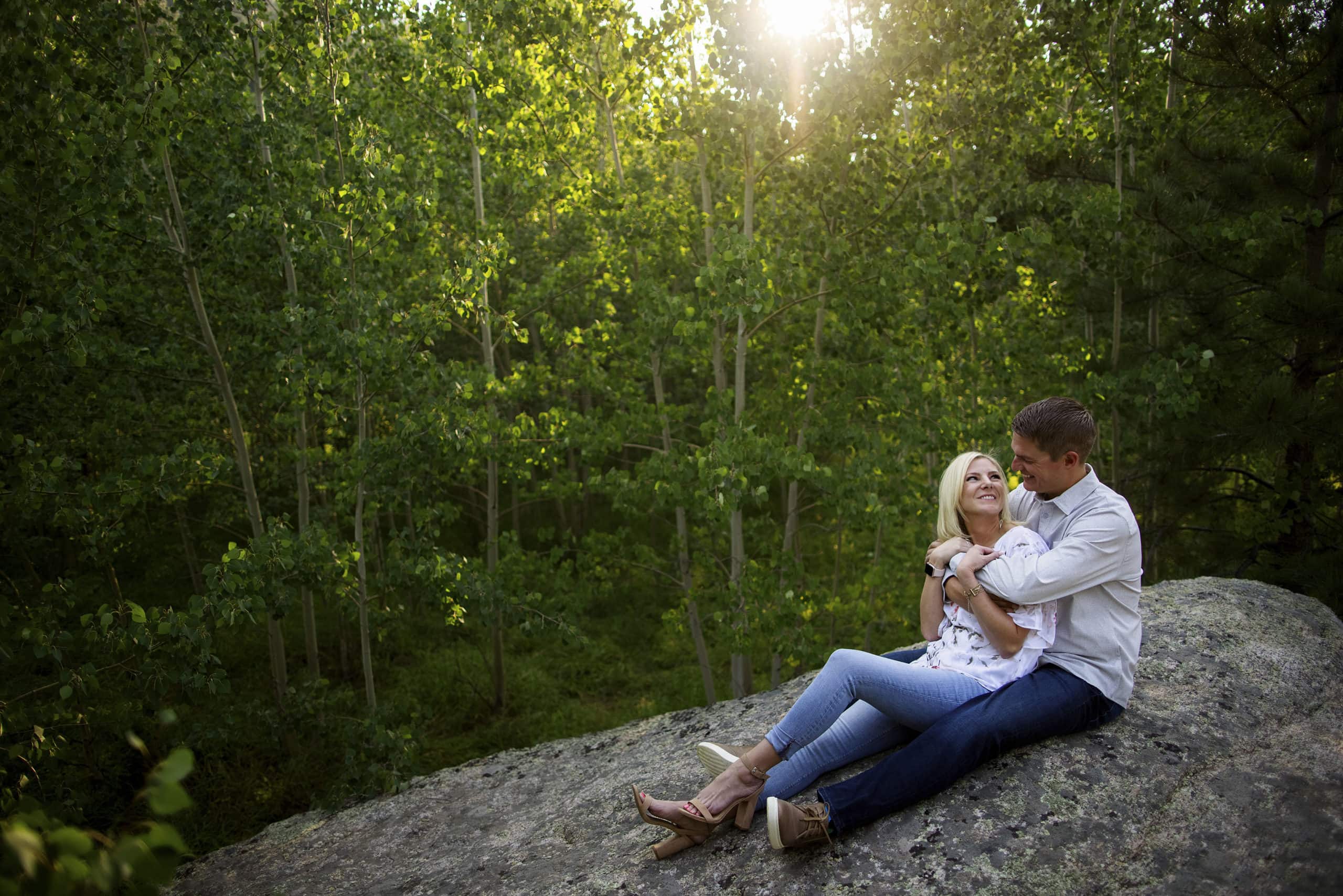 A couple share a moment together sitting on a rock near the Fall River entrance at Rocky Mountain National Park